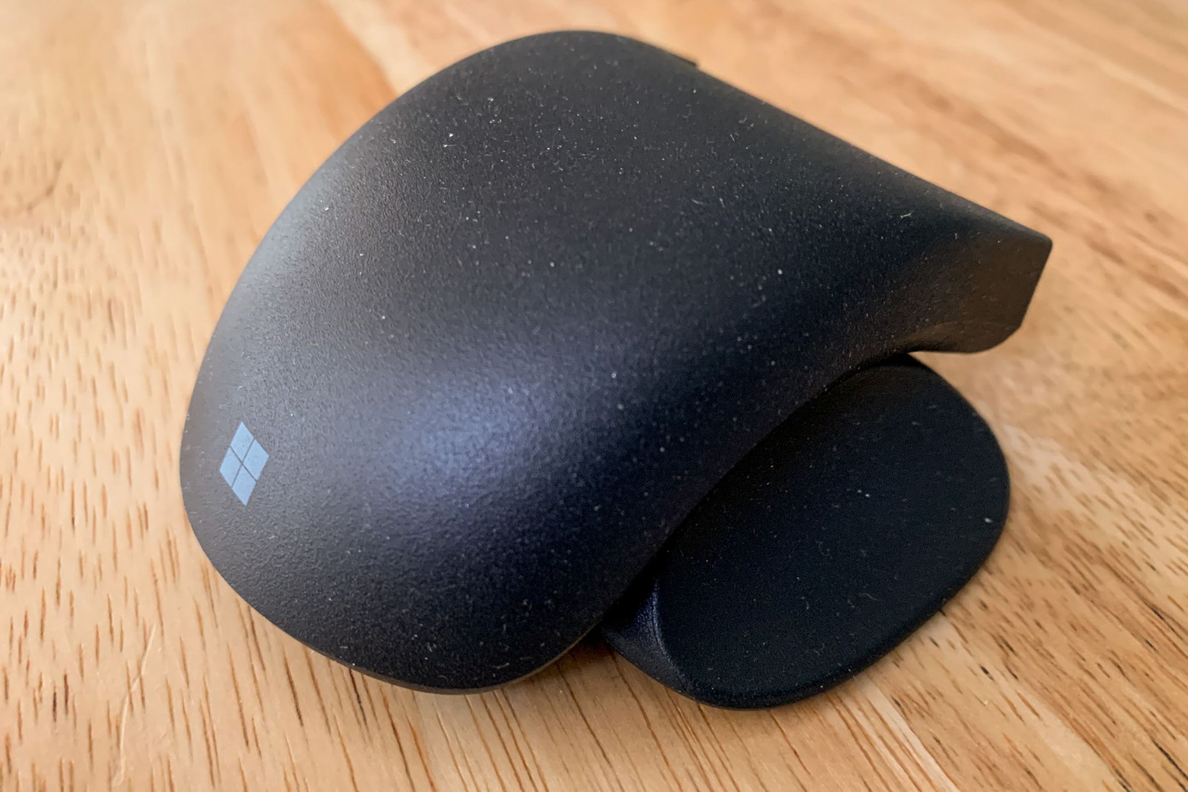 Close-up of a black adaptive mouse with thumb support.