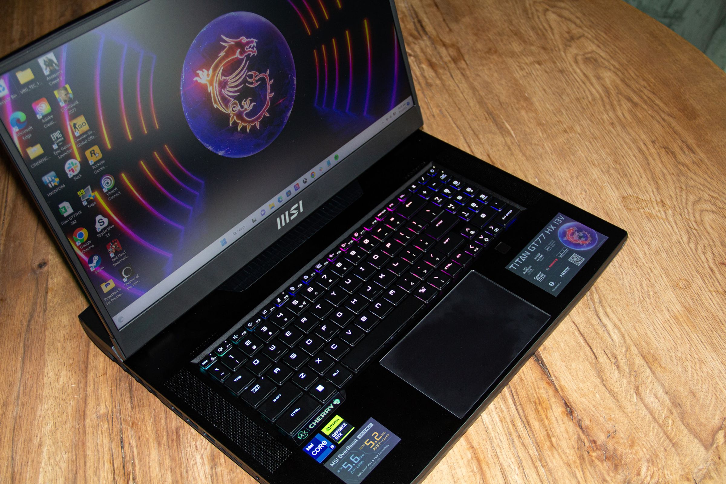 The MSI Titan GT77HX seen from above, with the MSI logo on a desktop background.