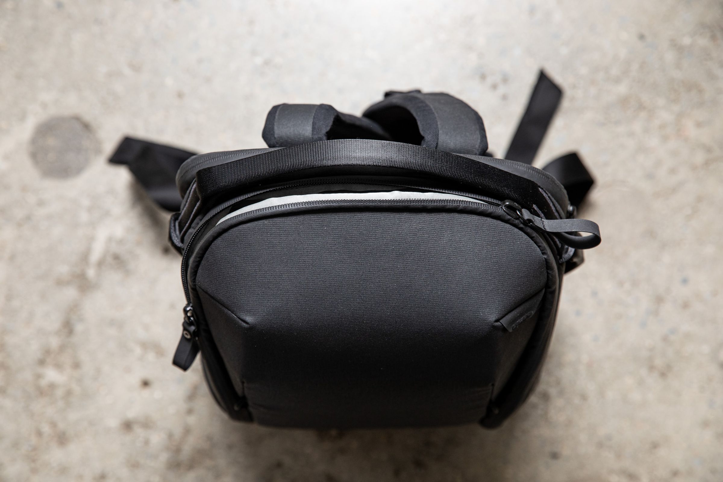 La parte superior de esta mochila negra Peak Design Everyday Backpack queda plana en el suelo.