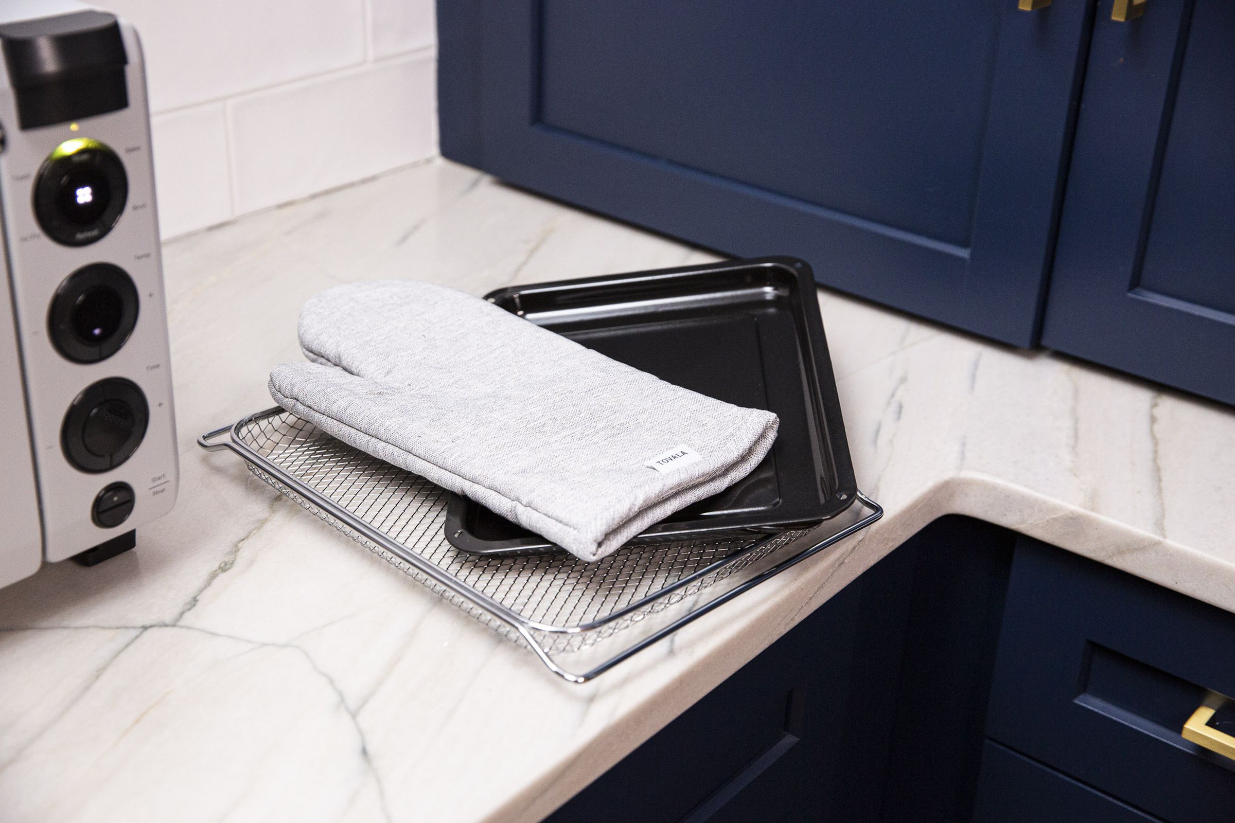 The Tovala comes with an air fry basket, a sheet tray, and an oven glove.