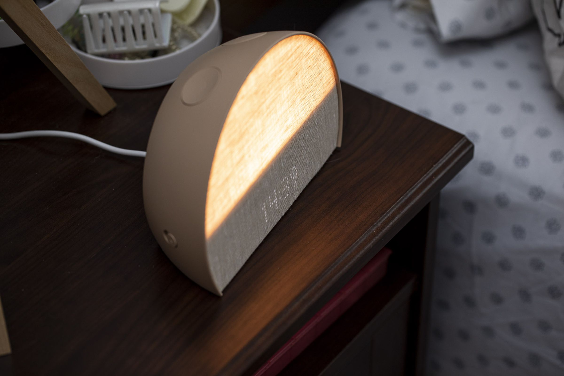 Angled view of the Hatch Restore 2 lit up on a nightstand