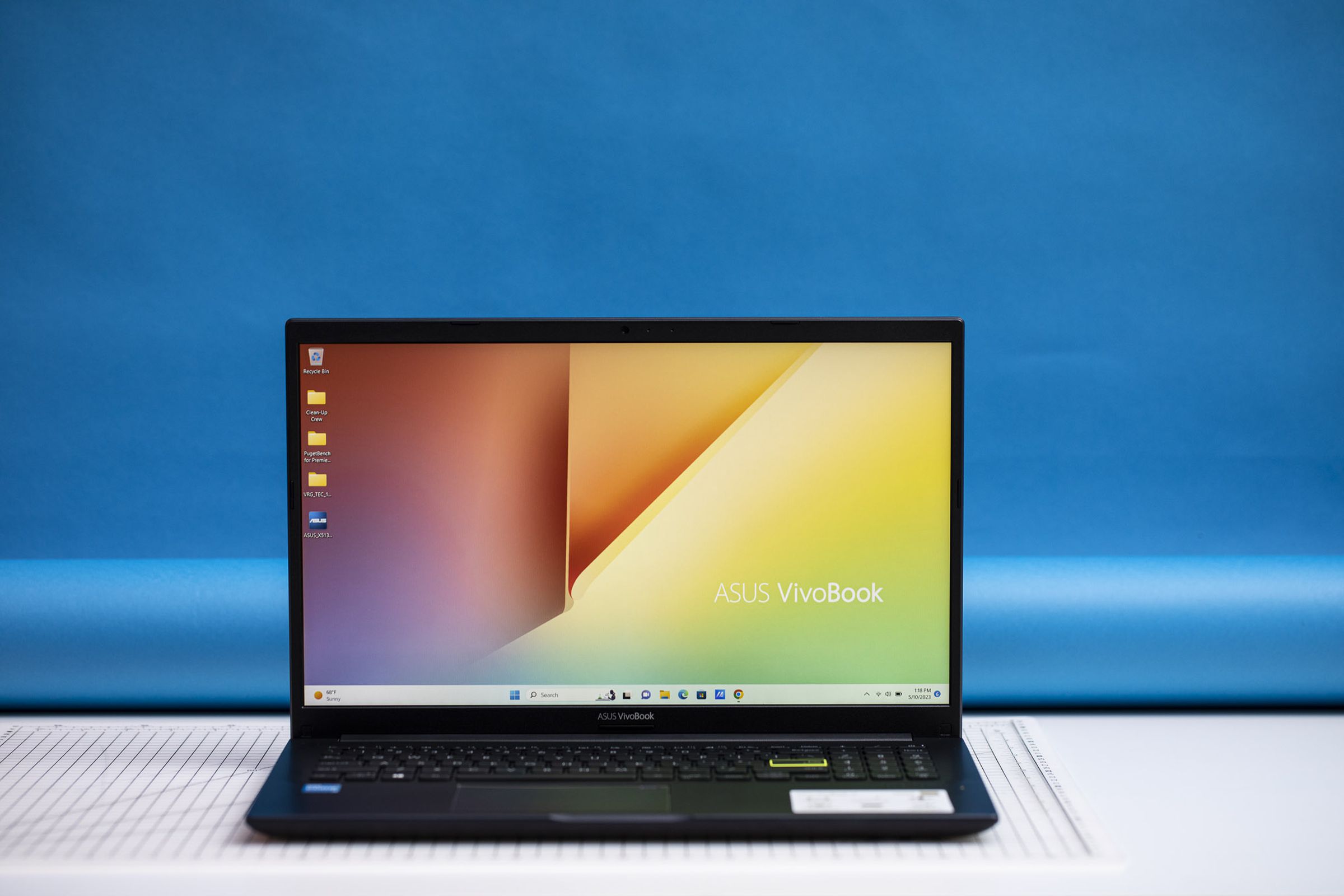 The Asus Vivobook 15 open, displaying a pastel desktop background.