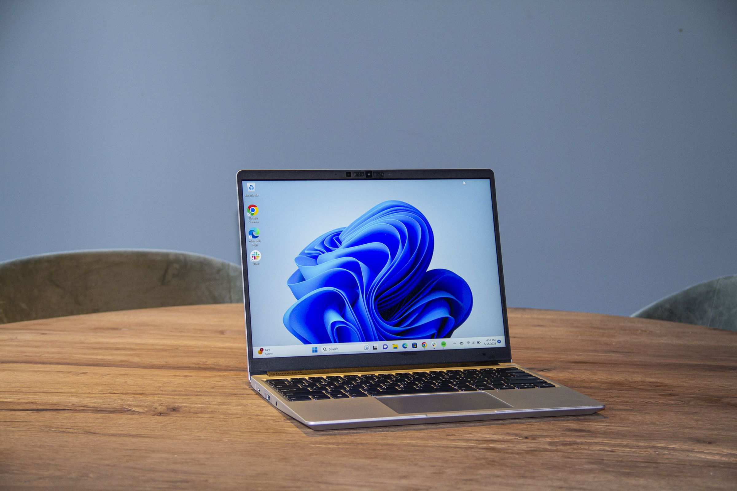 Best Laptop 2023: The Framework Laptop on a wooden table displaying a blue desktop background.