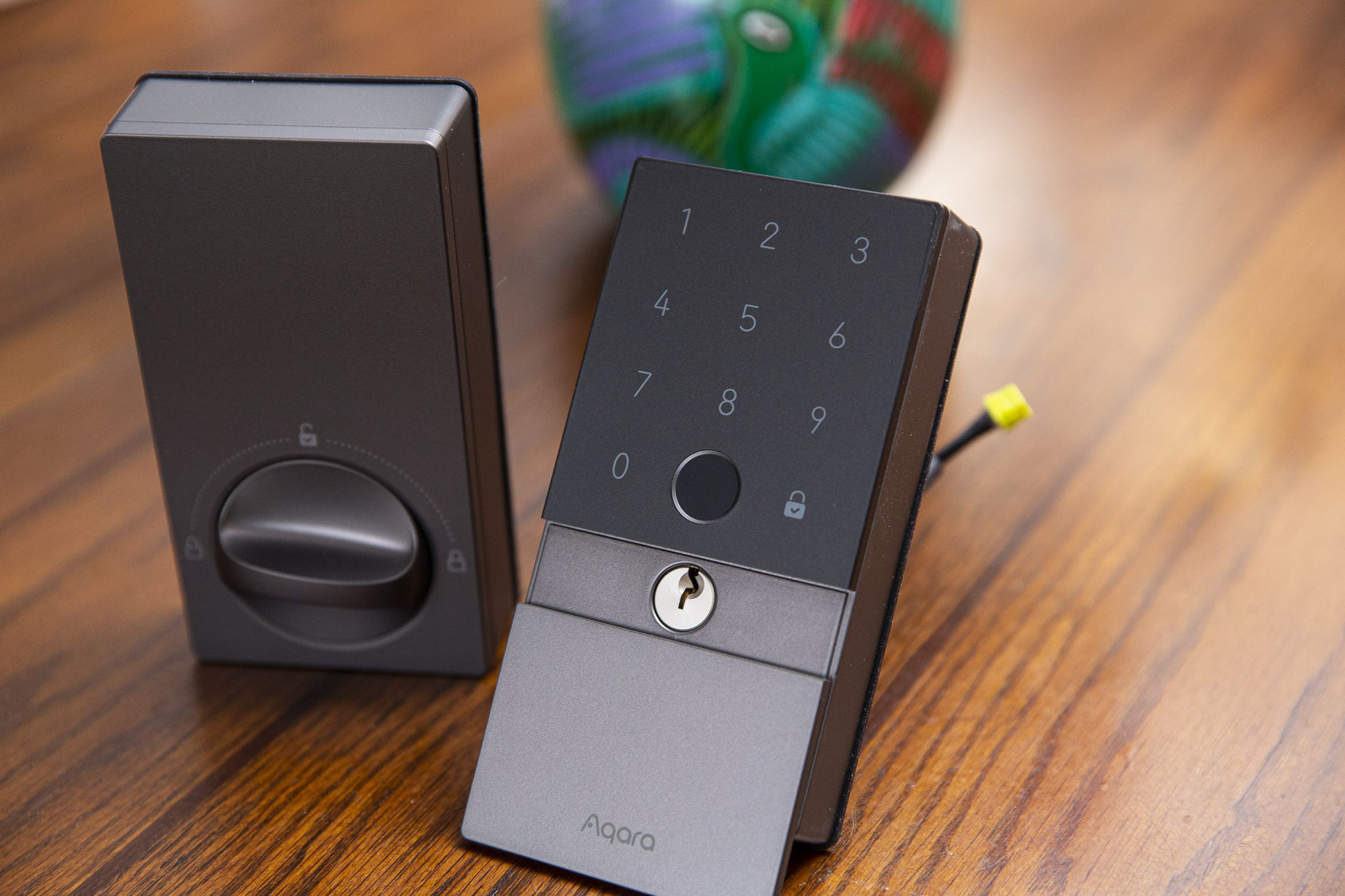The two parts of the Aqara smart lock on a table.