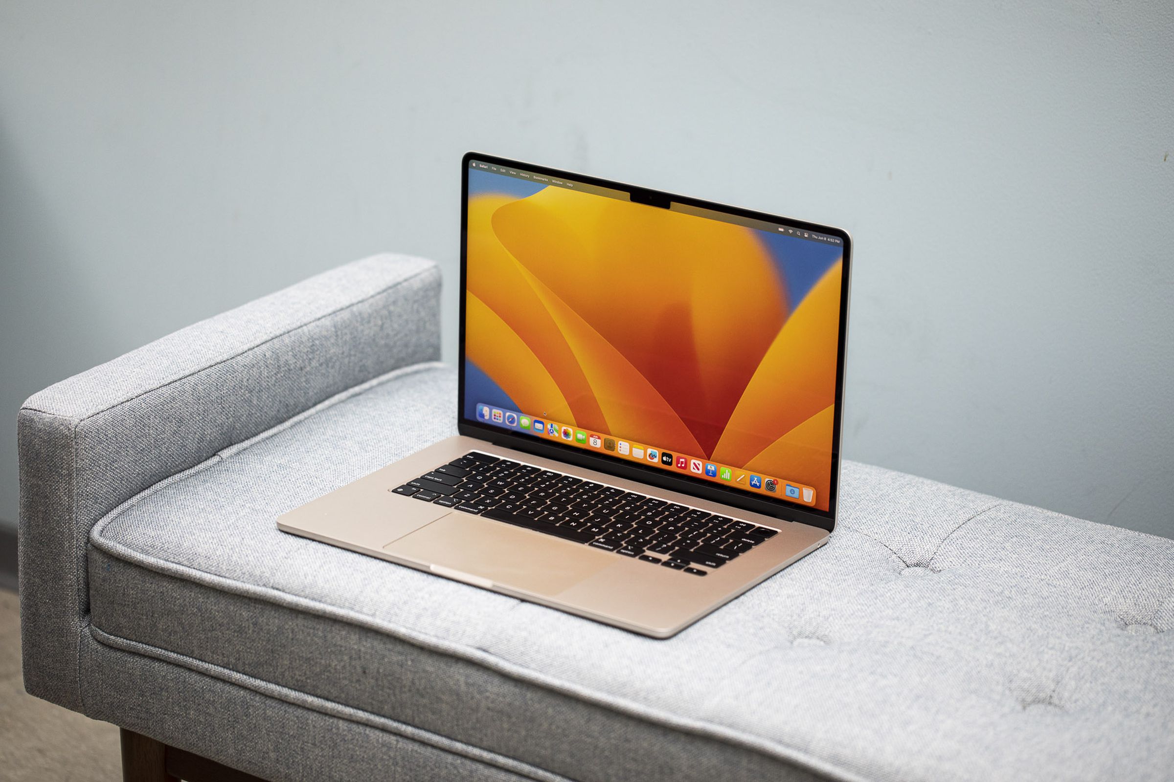 Best Laptop 2023: A Starlight MacBook Air 15-inch open on a gray couch.
