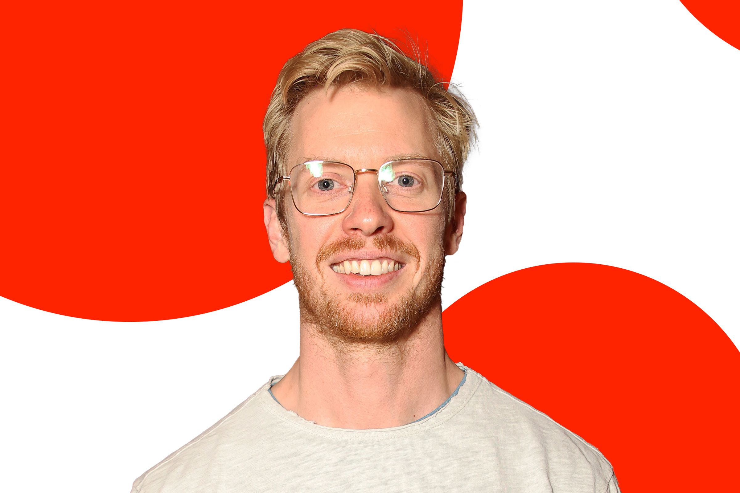 A photo of Reddit CEO Steve Huffman over an orange and white background.