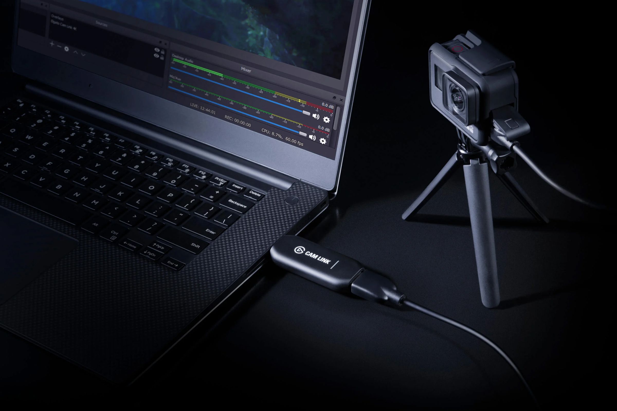 Elgato’s Cam Link 4K dongle plugged into the USB port of a laptop, with a GoPro action camera plugged into its HDMI port.