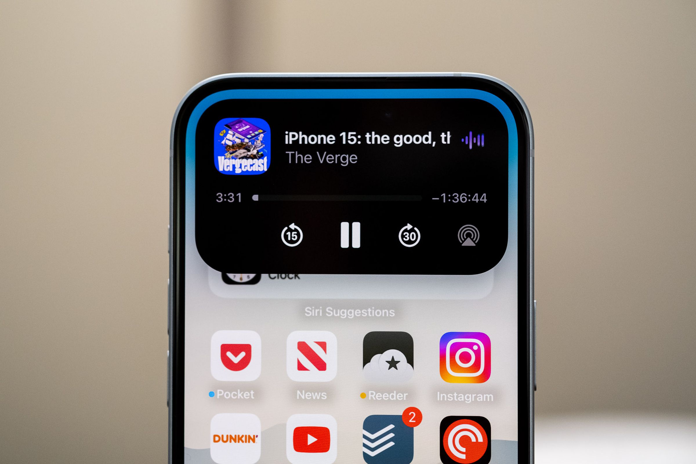 The Dynamic Island on the iPhone 15 showing a currently playing podcast