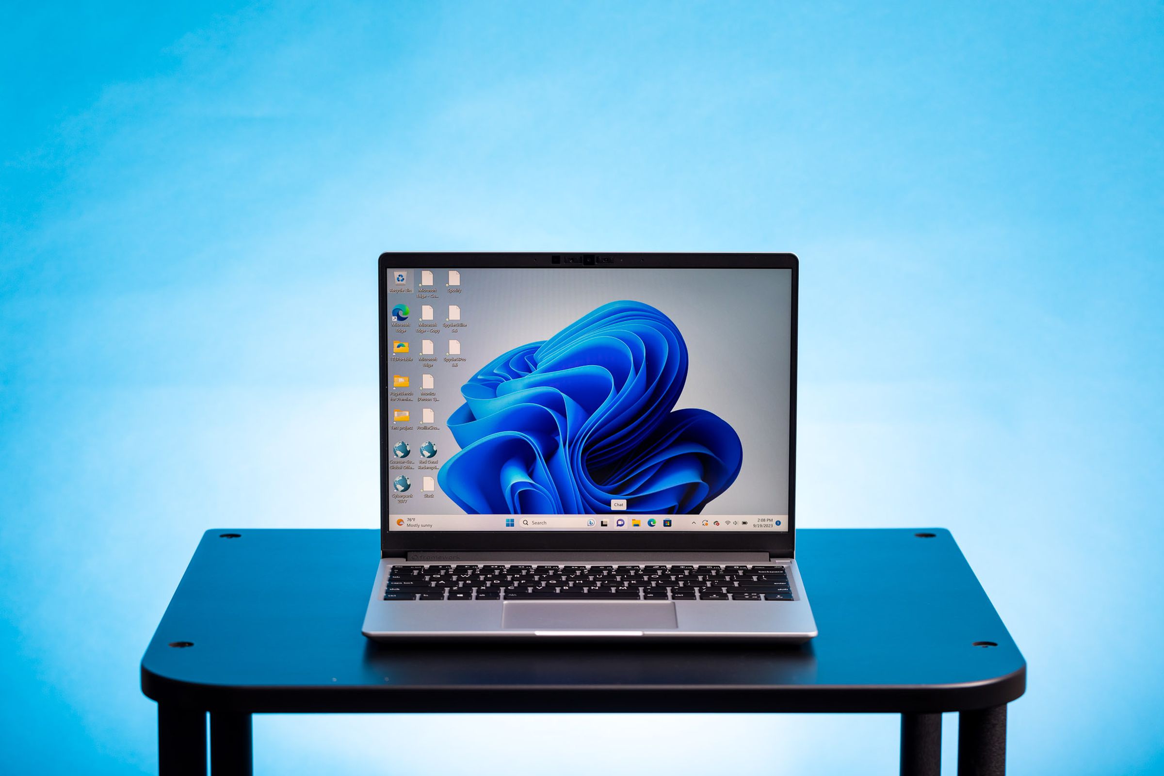 The Framework Laptop 13 (AMD) displaying a blue Windows desktop background.