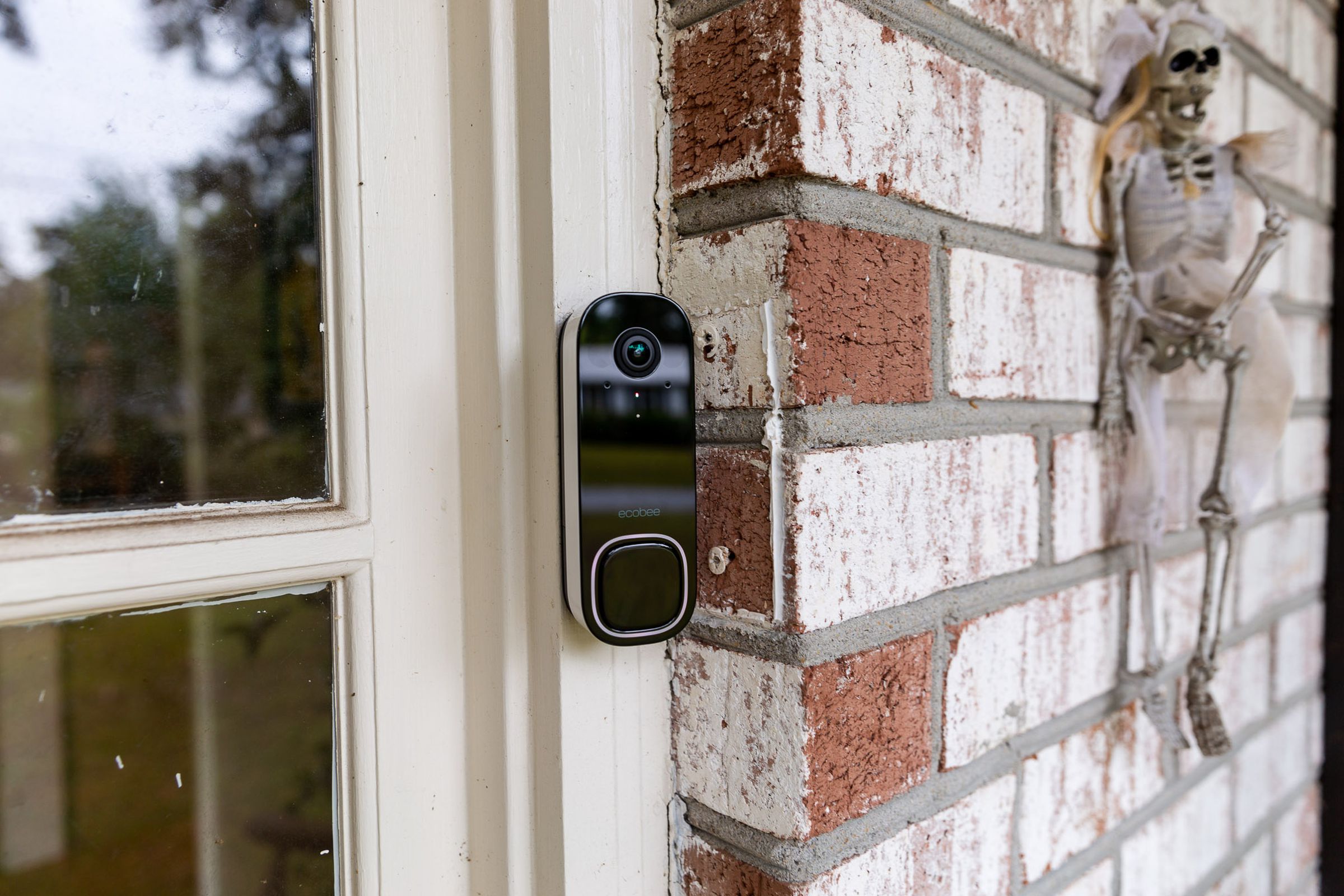 The Ecobee Smart Doorbell Camera is large for a wired doorbell, with a black glass front and a white trim.