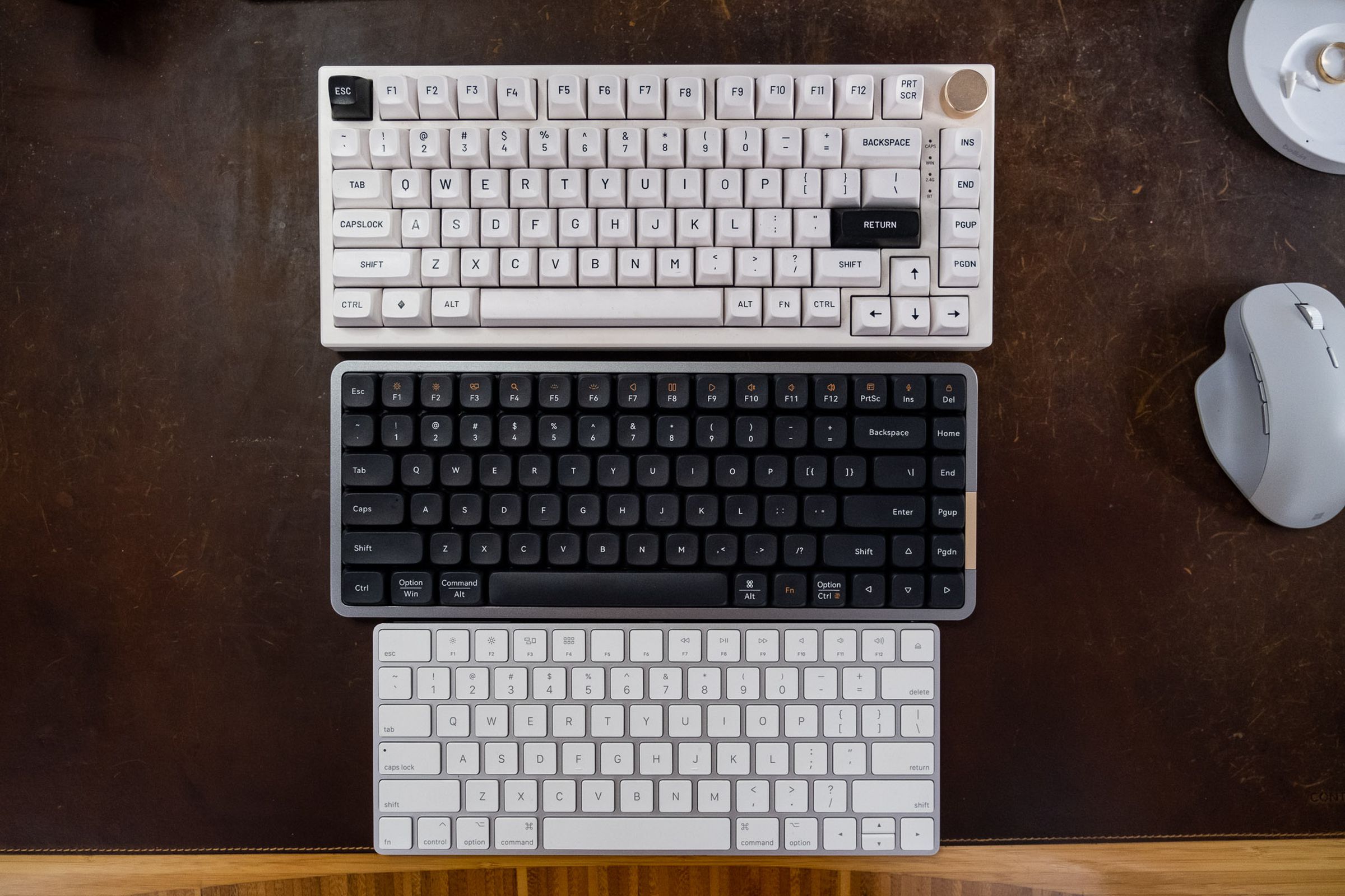 A full-height mechanical keyboard, a Lofree Flow, and an Apple Magic Keyboard viewed from above.