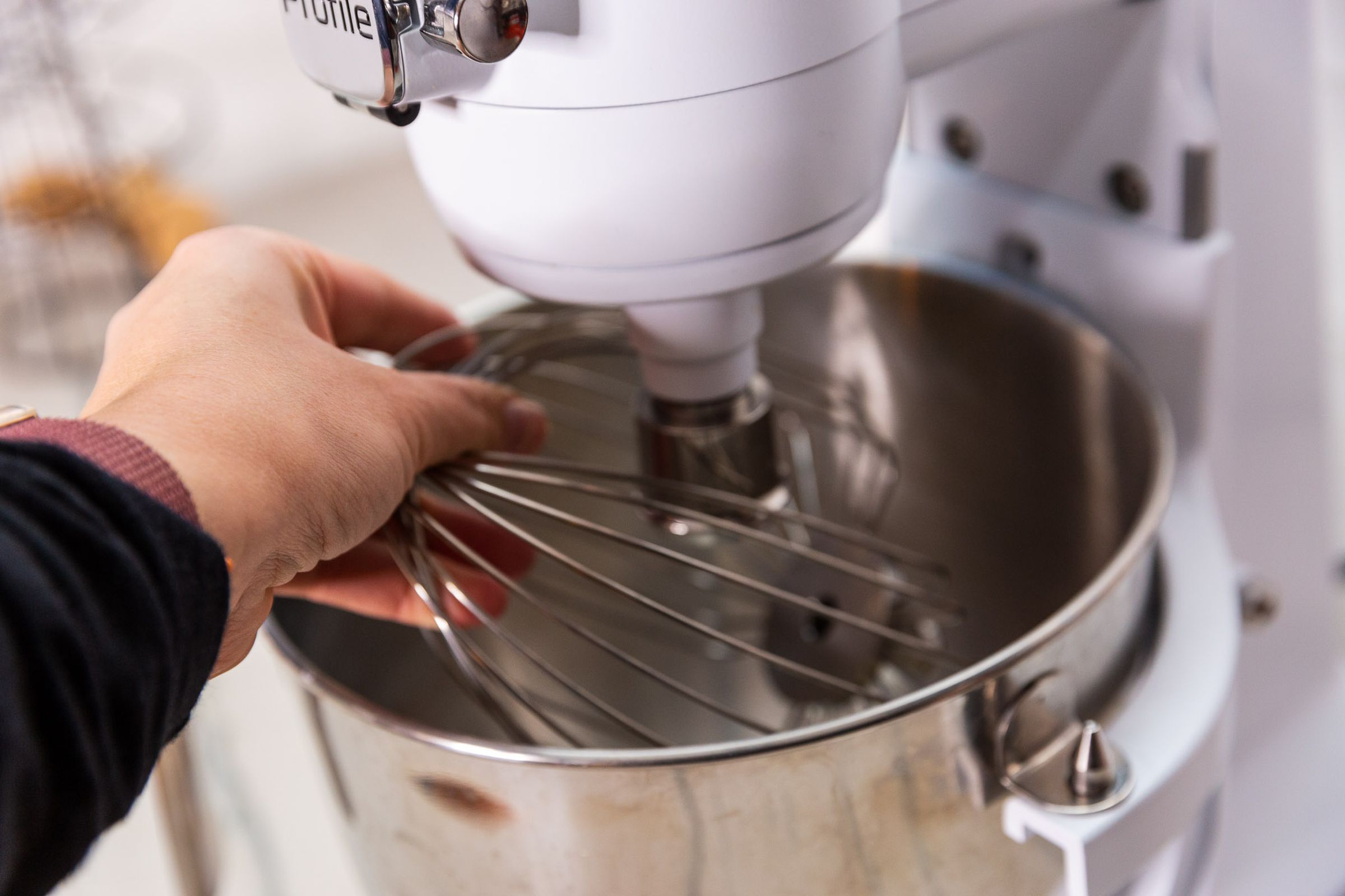 The mixer is not a tilt head, so the whisk attachment is designed with a cutout so that it can fit into the bowl.