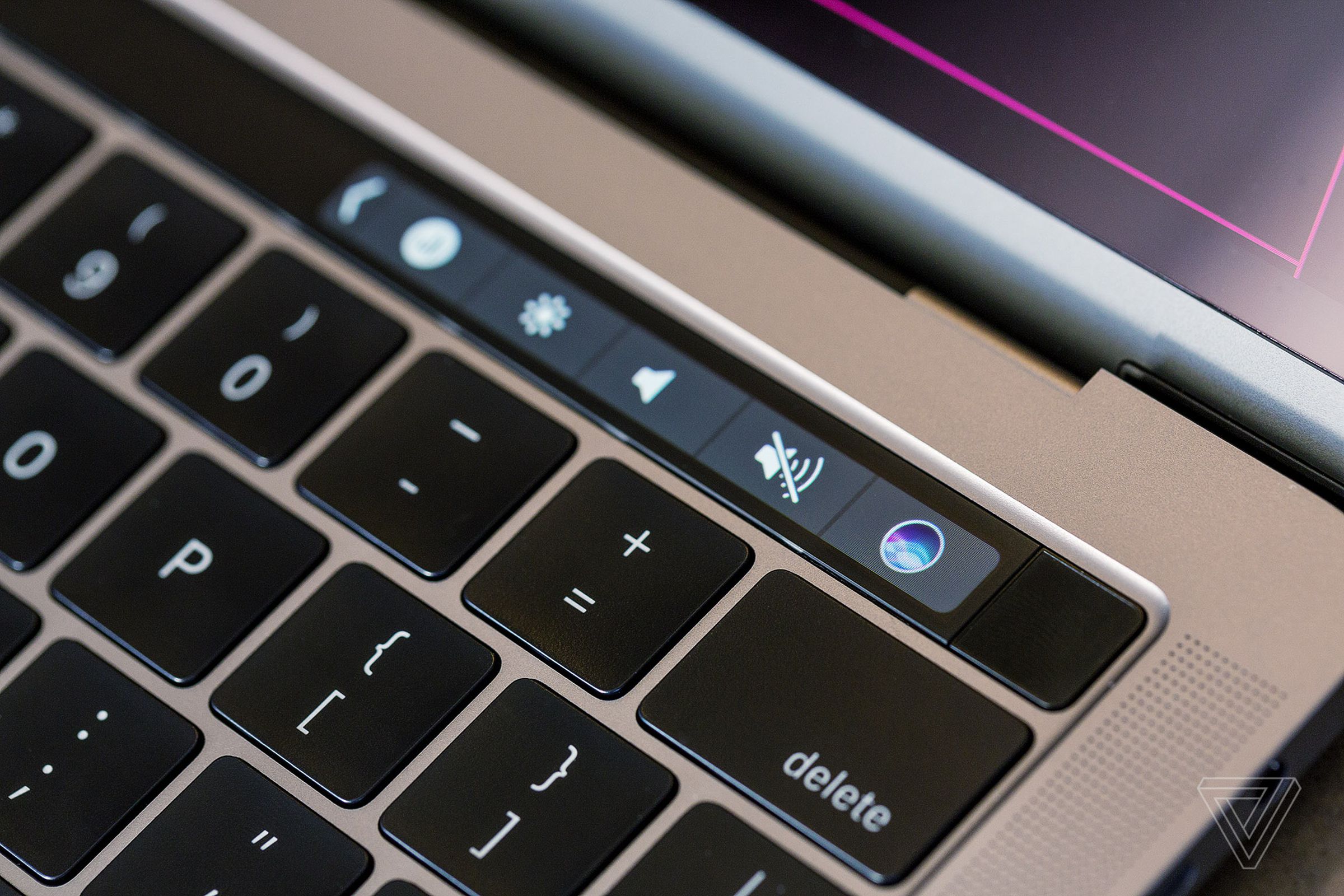 An image of the Touch Bar with the contextual Siri button prominently displayed.