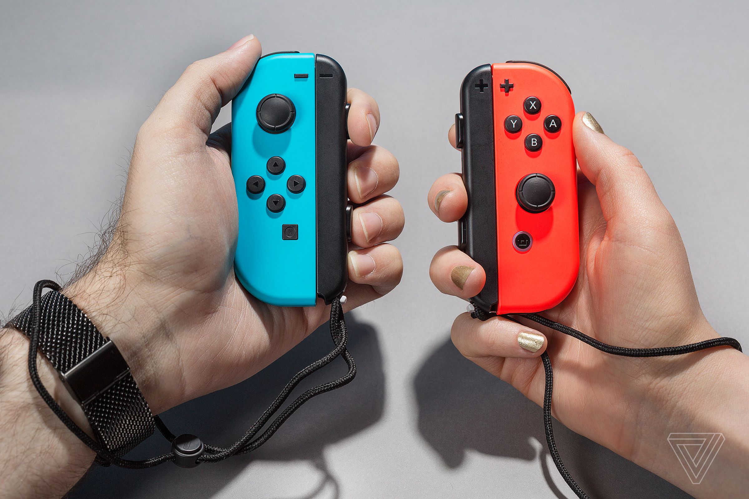 An image showing someone holding blue and red Joy-Cons in their hands