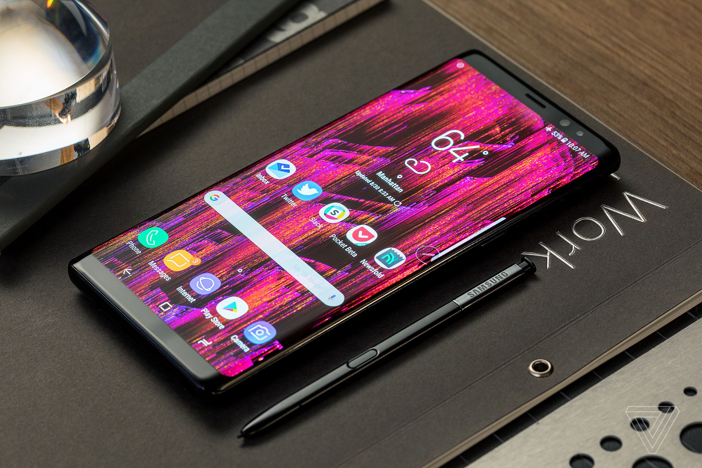 A Galaxy Note 8 rests on a table. The stylus is next to it.