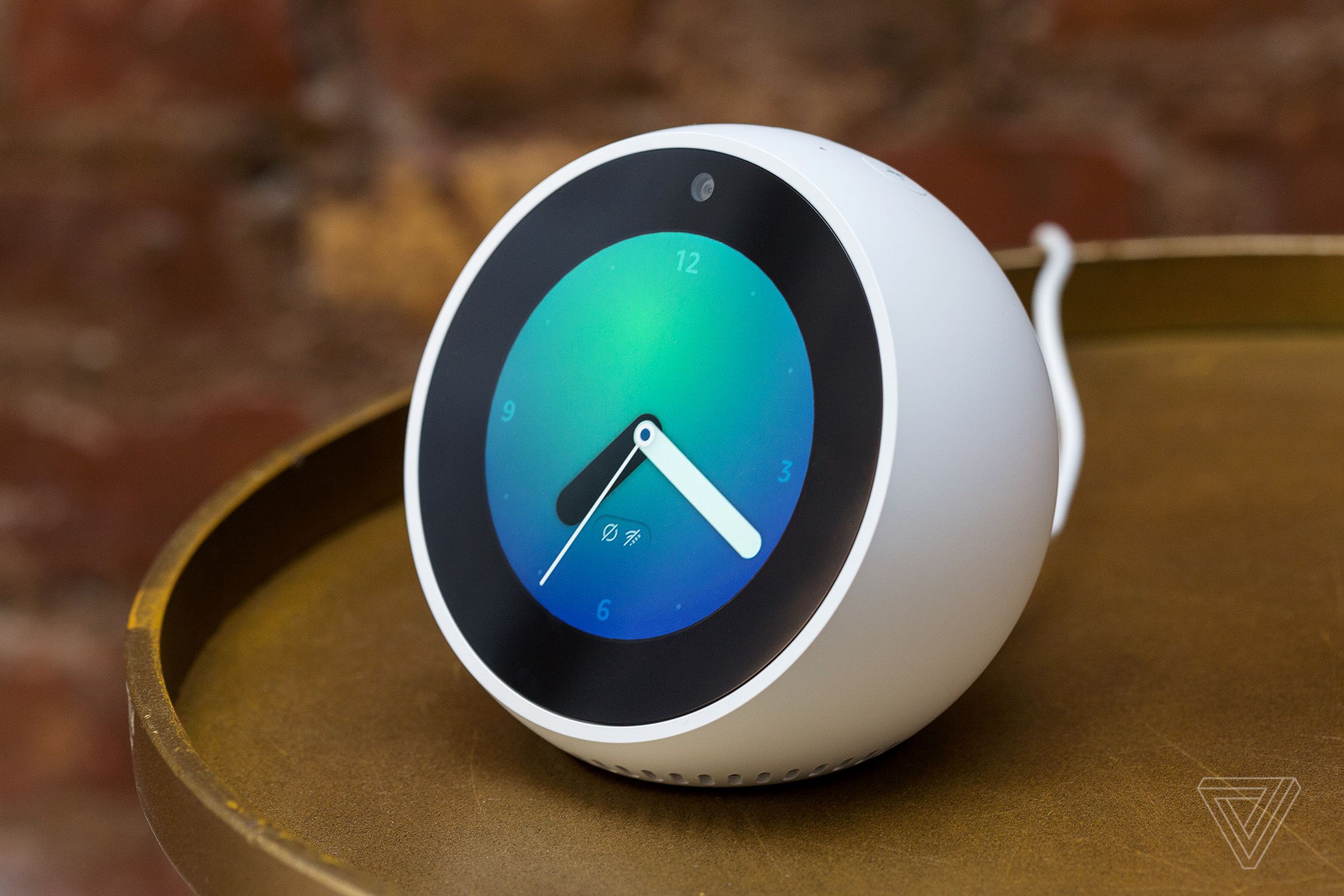 A versão 2017 do Amazon Echo Spot, uma meia-luva redonda com aparência de relógio em uma mesa.