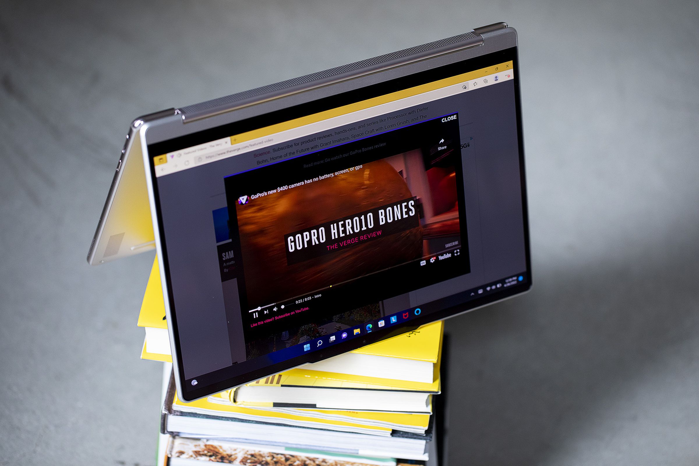 The Lenovo Yoga 9i in tent mode atop a stack of books.