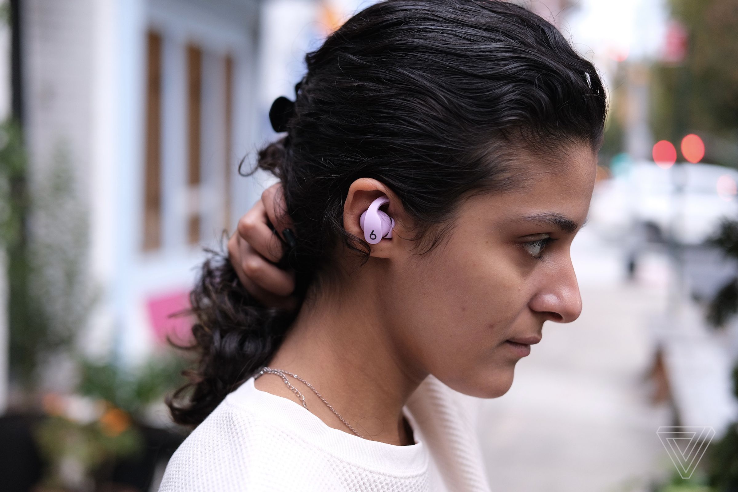 A side-profile image of the Beats Fit Pro earbuds pictured in a woman’s right ear.