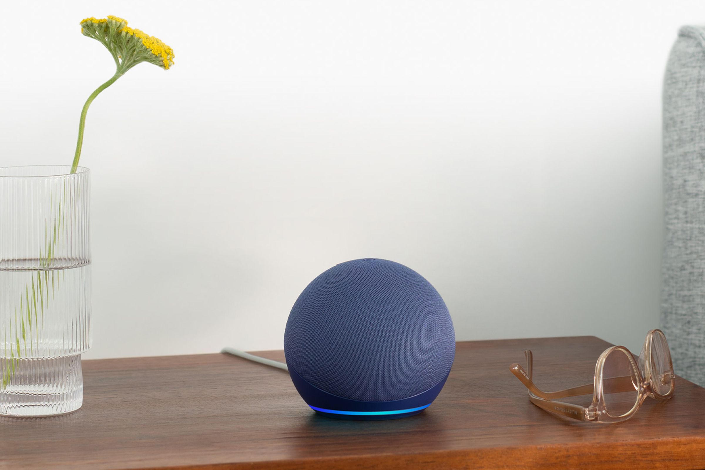 An Amazon Echo Dot (fifth-gen) in blue, resting on a side table.