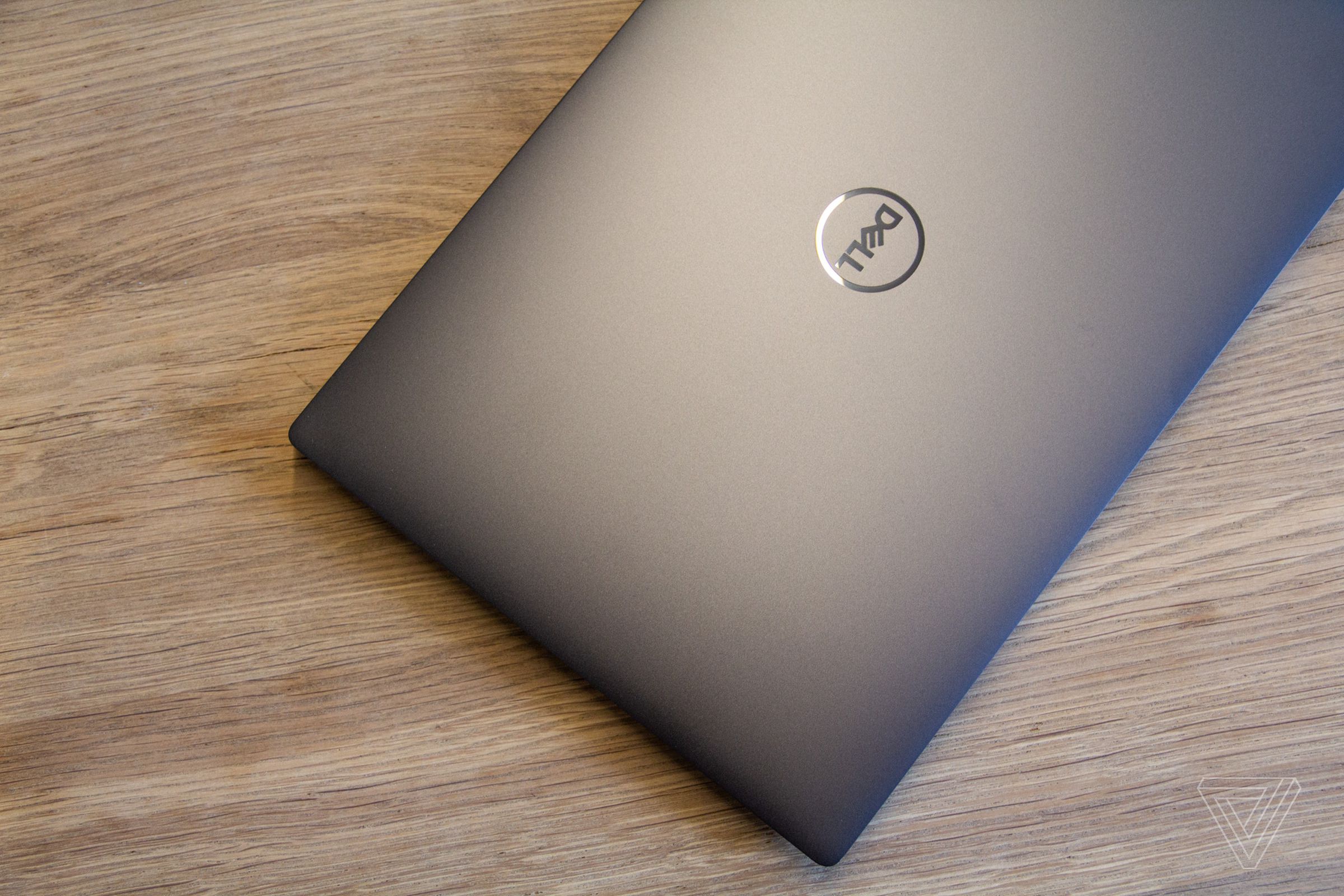 The lid of the Dell XPS 13 Plus on a wooden table seen from above.