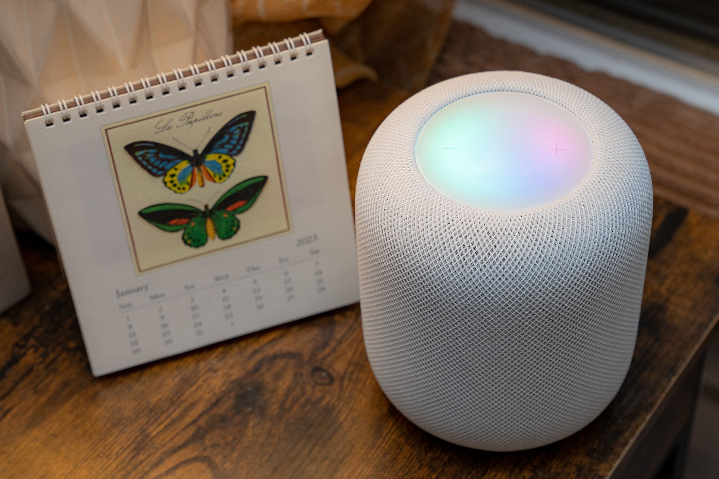A photo of Apple’s second-generation HomePod with an illuminated touch surface.