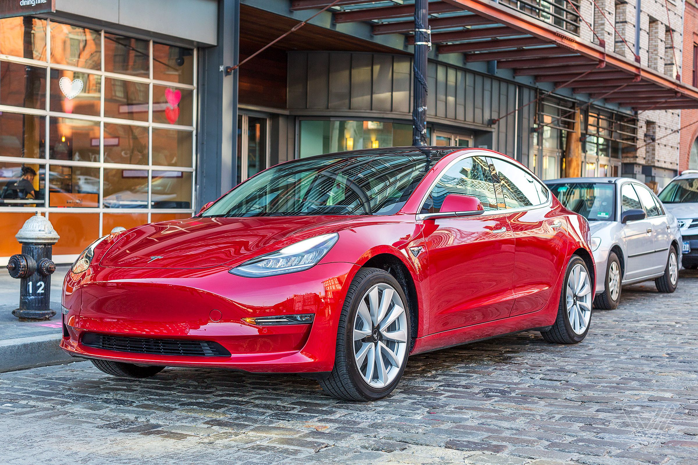 a very shiny red sedan with lots of curves