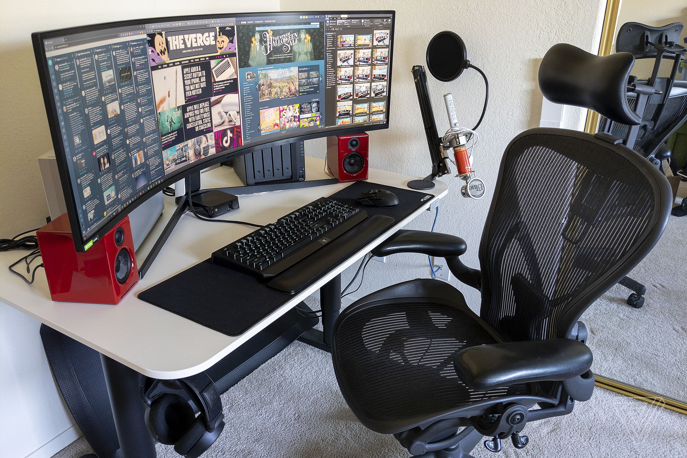 A photograph of a work-from-home setup using the Samsung Odyssey G9 gaming monitor