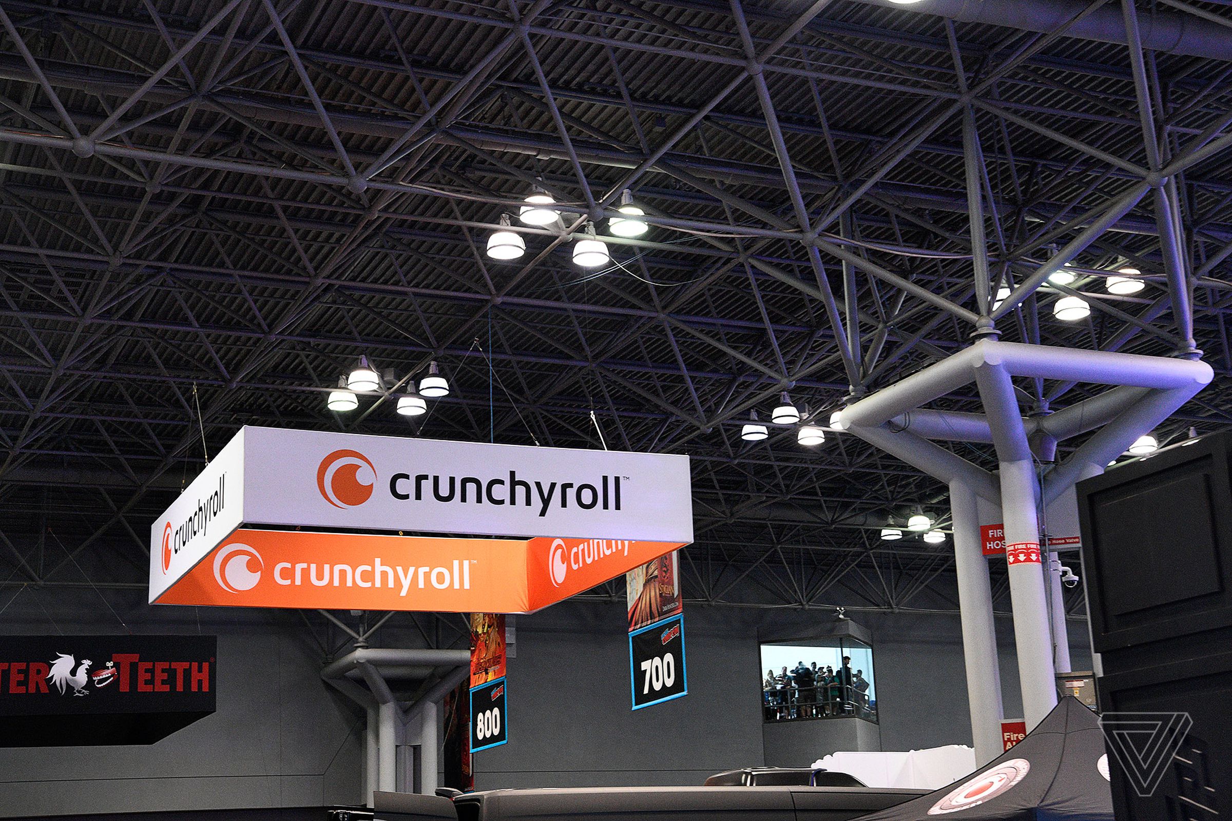 An image of a orange and white banner on a booth saying Crunchyroll.