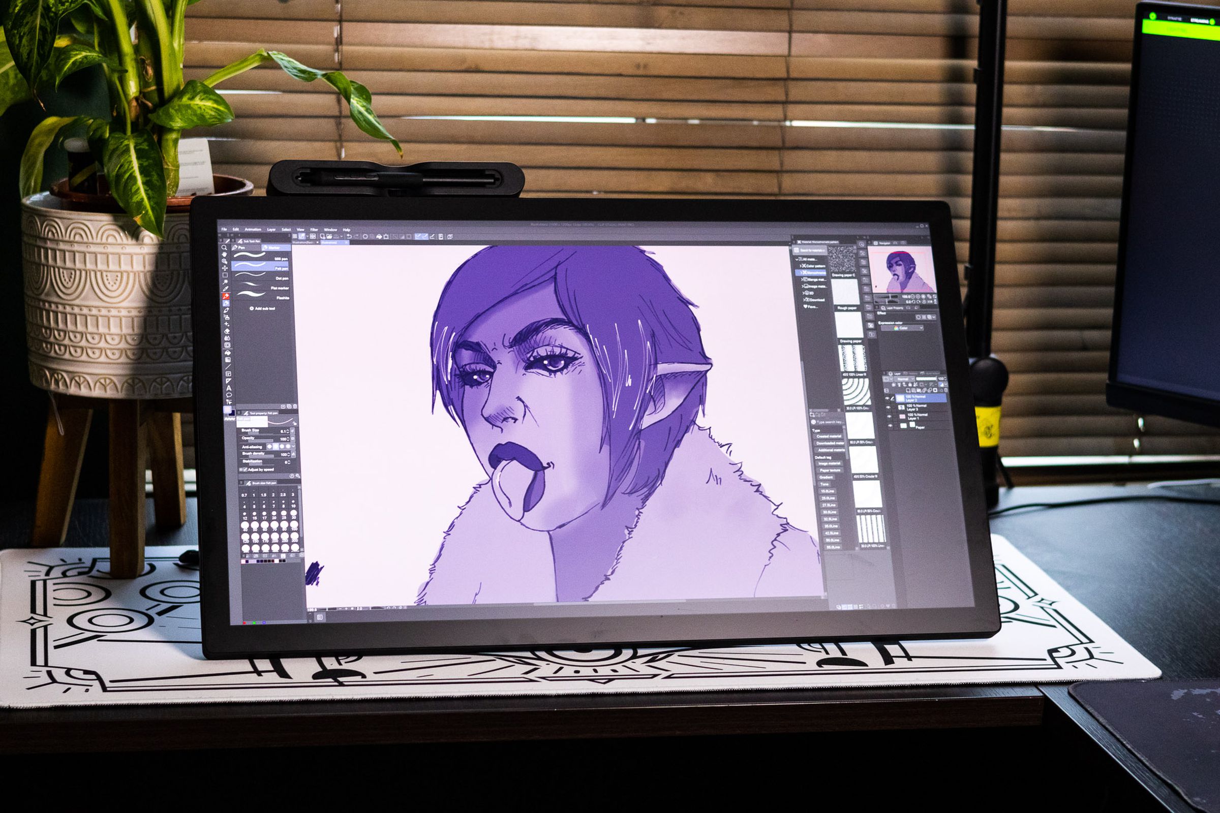 The Wacom Cintiq Pro 27 Creative Pen Display on a desk, displaying a purple illustration.