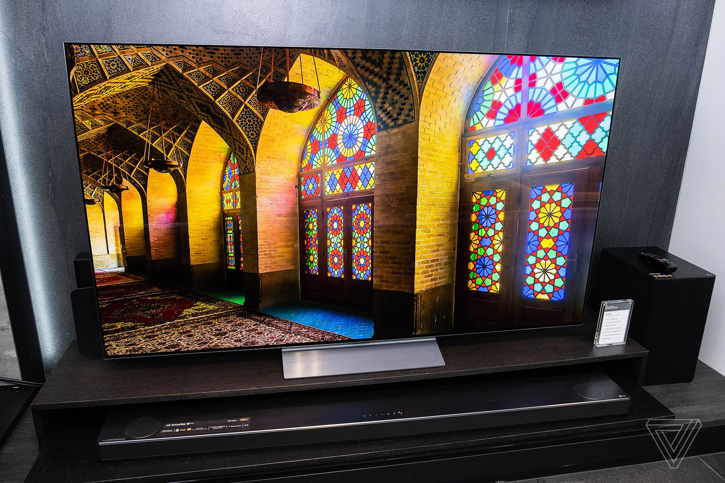 An LG C2 OLED television displays the colorful interior of a building with stained glass.