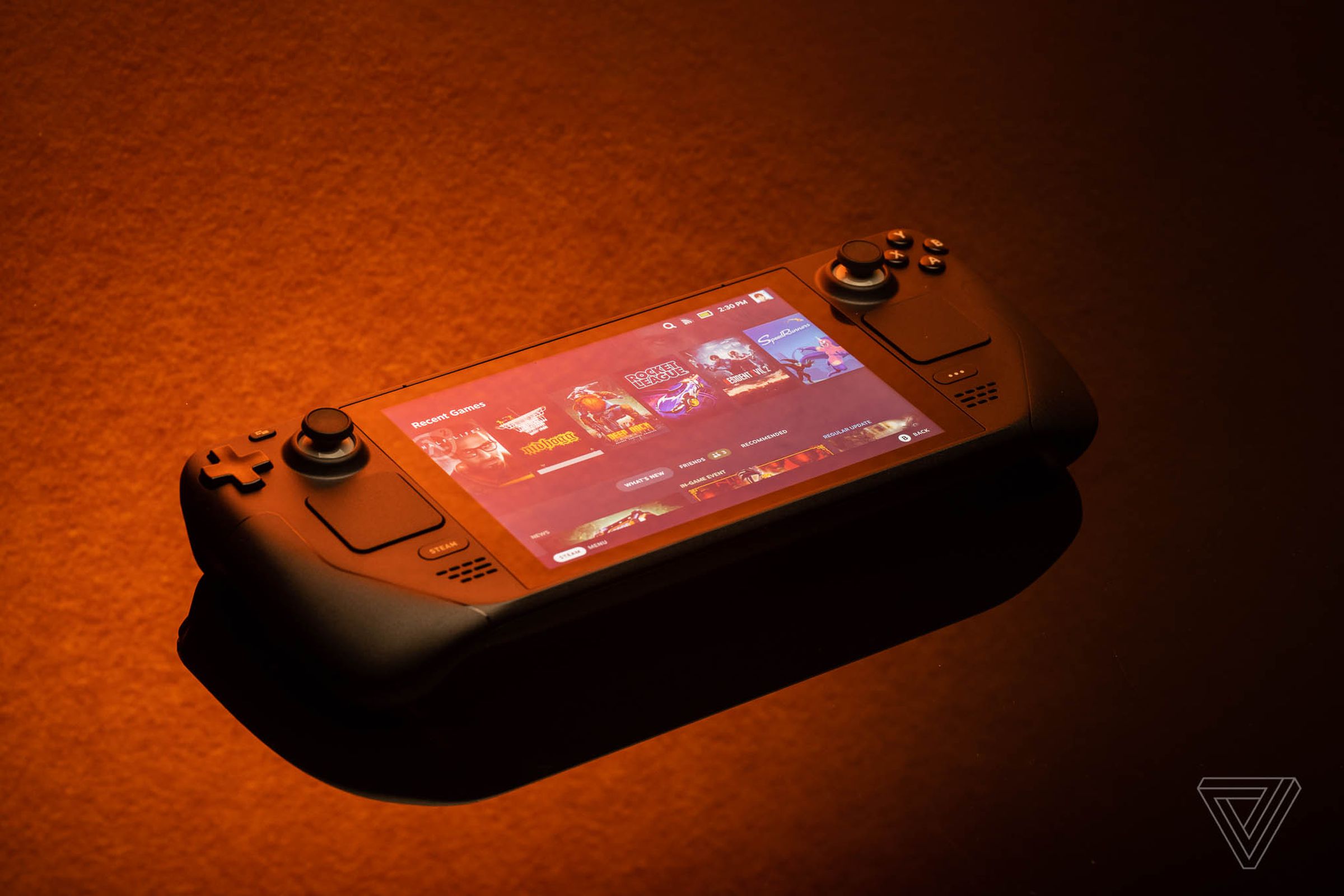The Steam Deck gaming handheld, lit solely by orange light, giving a bit of a sunset or fire feel
