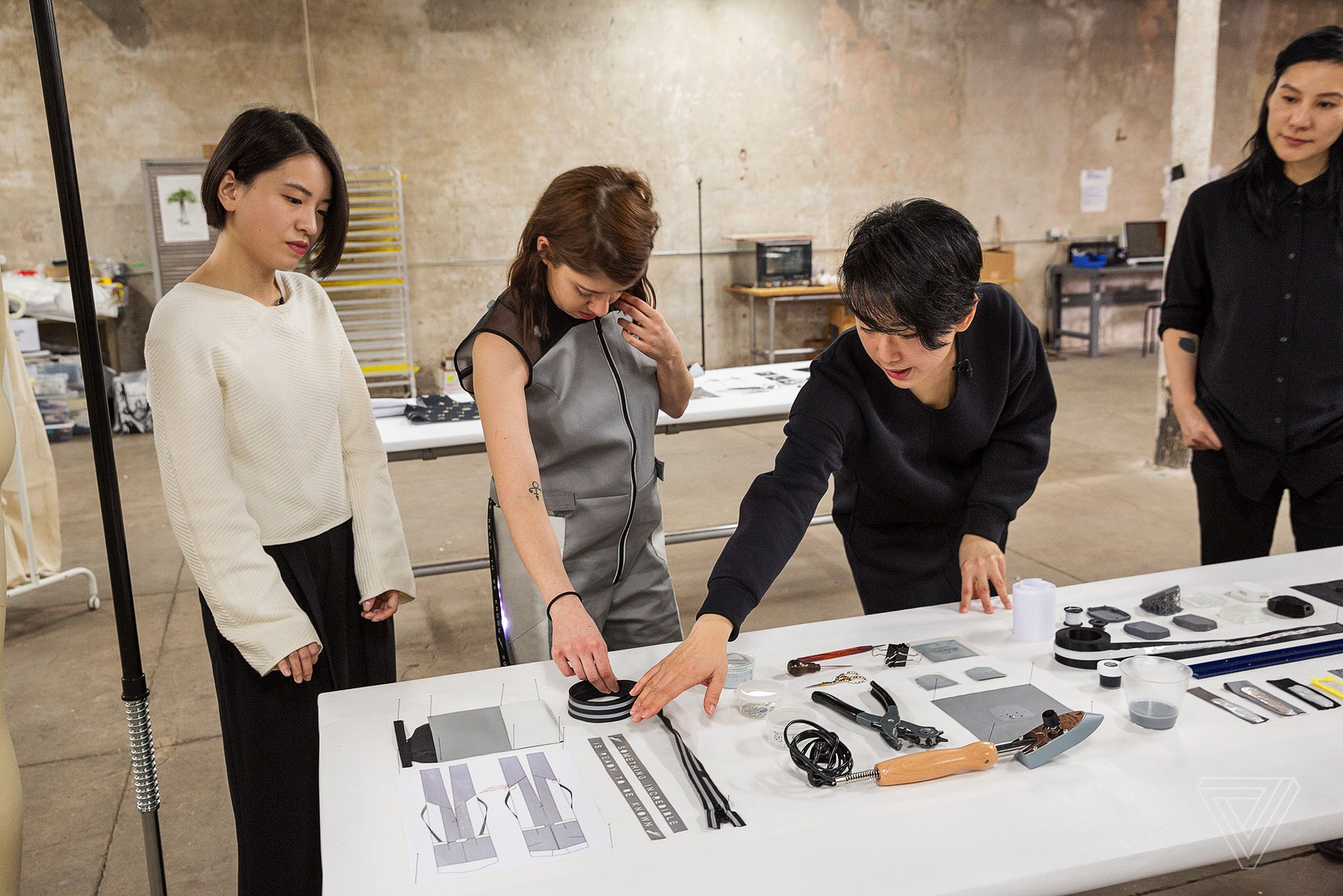 Jingwen Zhu, Yuchen Zhang, and Hellyn Teng walk Lizzie Plaugic through materials and early prototyped elements of their garments.