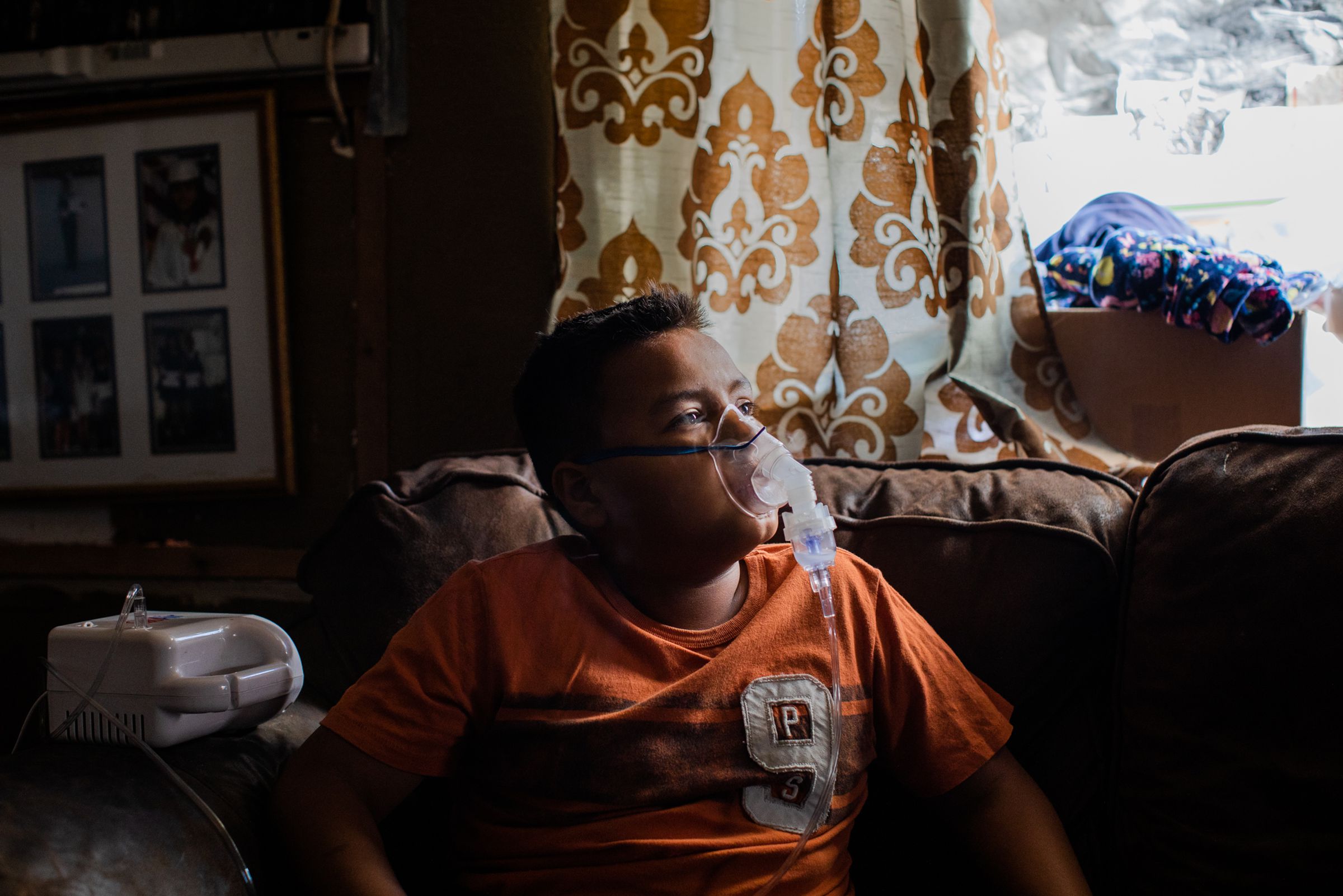 John Paul Castro takes his nebulizer treatment at his home in El Centro, California.
