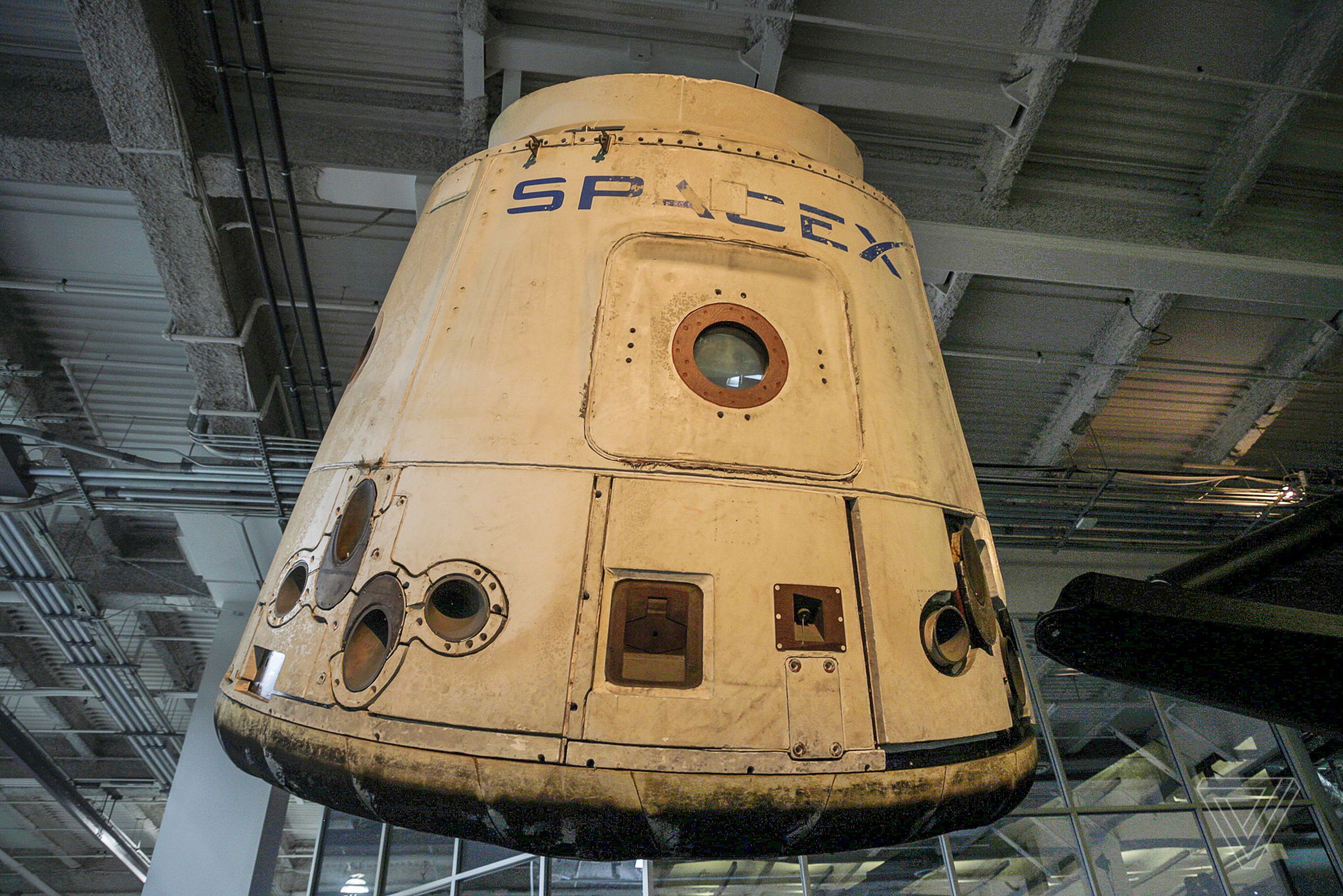 The first Dragon cargo capsule that ever flew to space hangs over SpaceX’s headquarters.