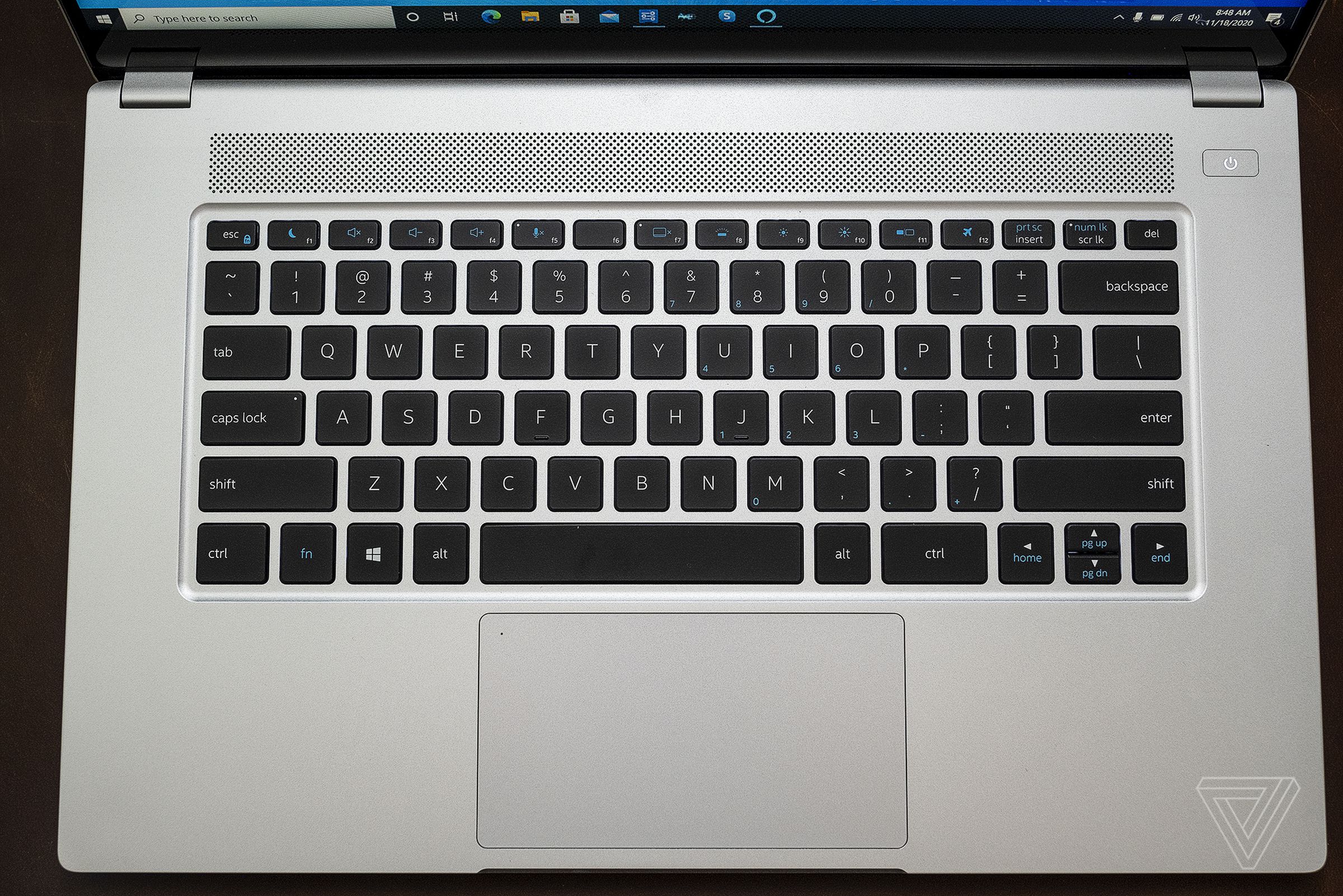 A full-size backlit keyboard is centered above a large glass trackpad.