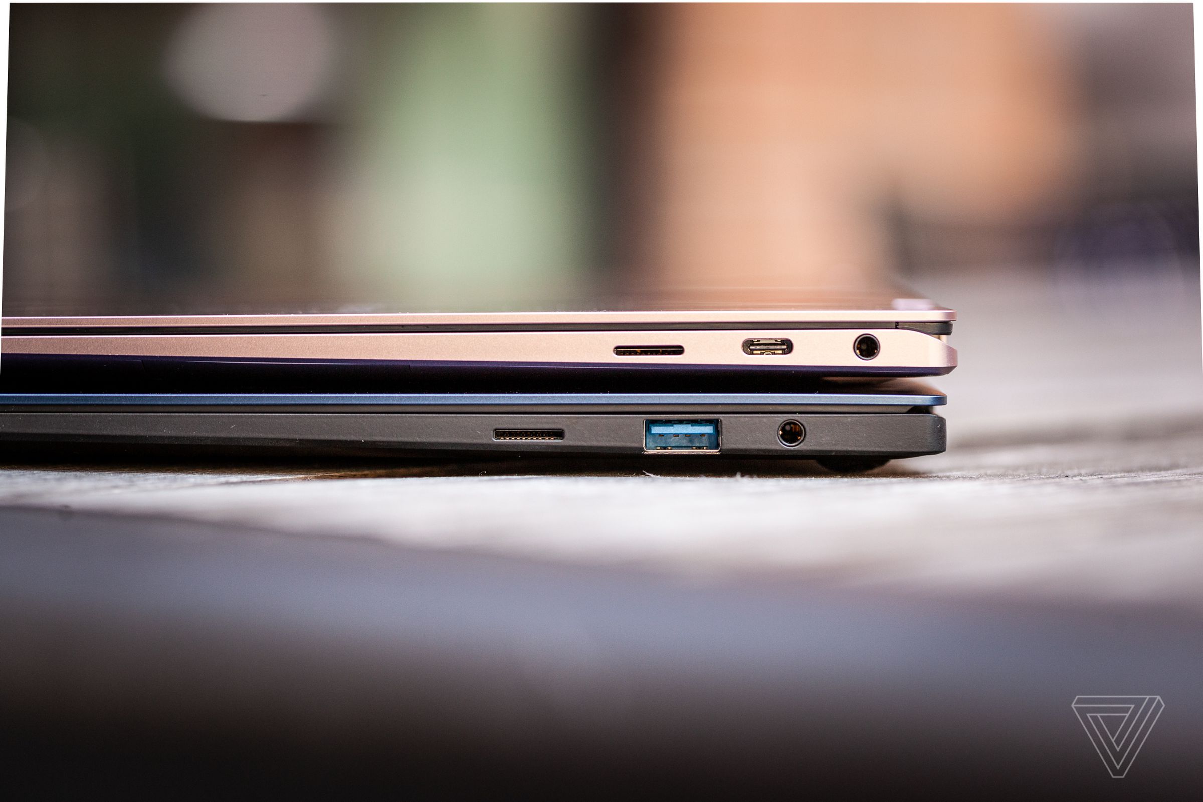 The Samsung Galaxy Book Pro 360 stacked on top of the Samsung Galaxy Book Pro, both closed on a picnic table.