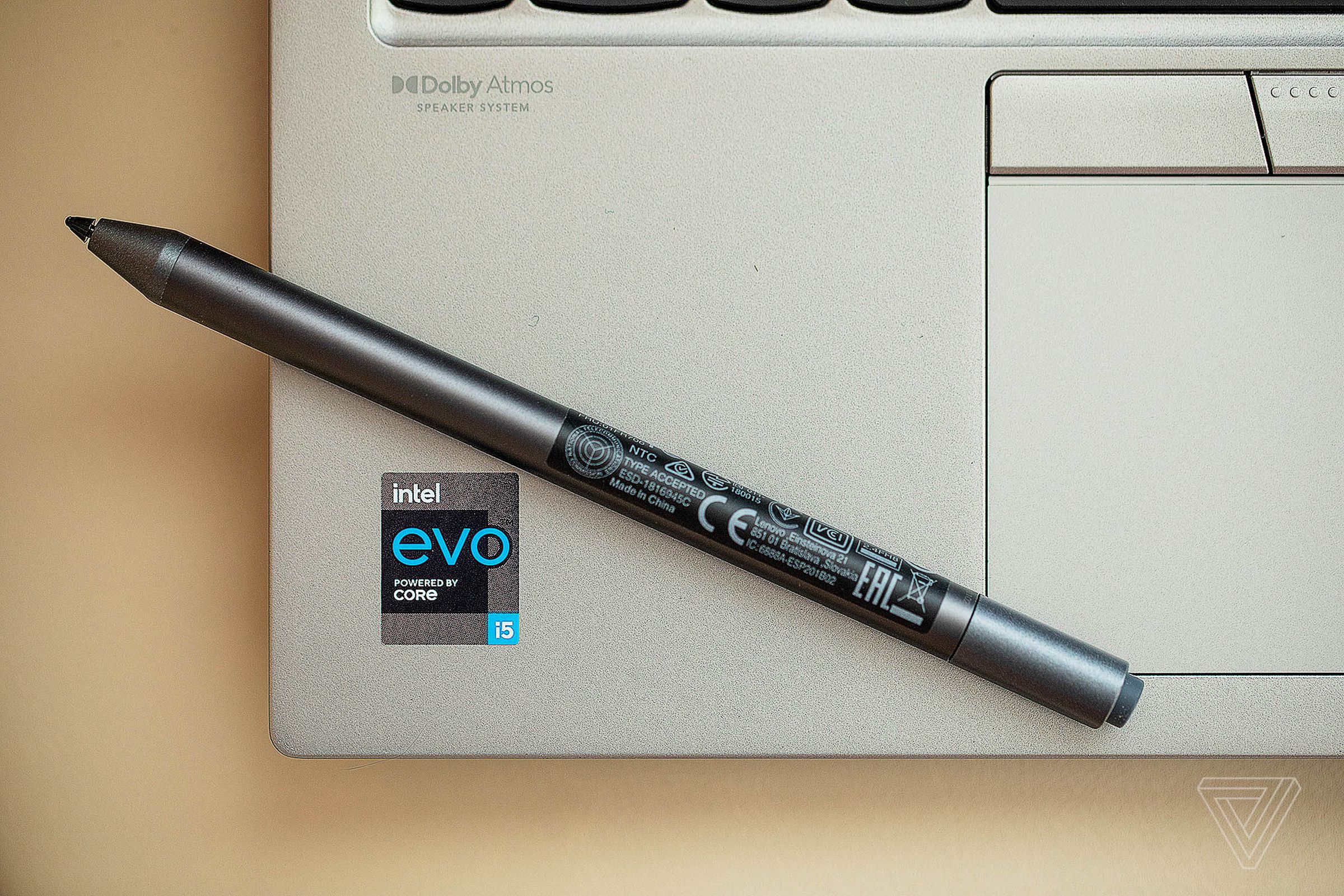 The left palm rest of the Lenovo ThinkPad X1 Titanium Yoga with the stylus laid diagonally across it.
