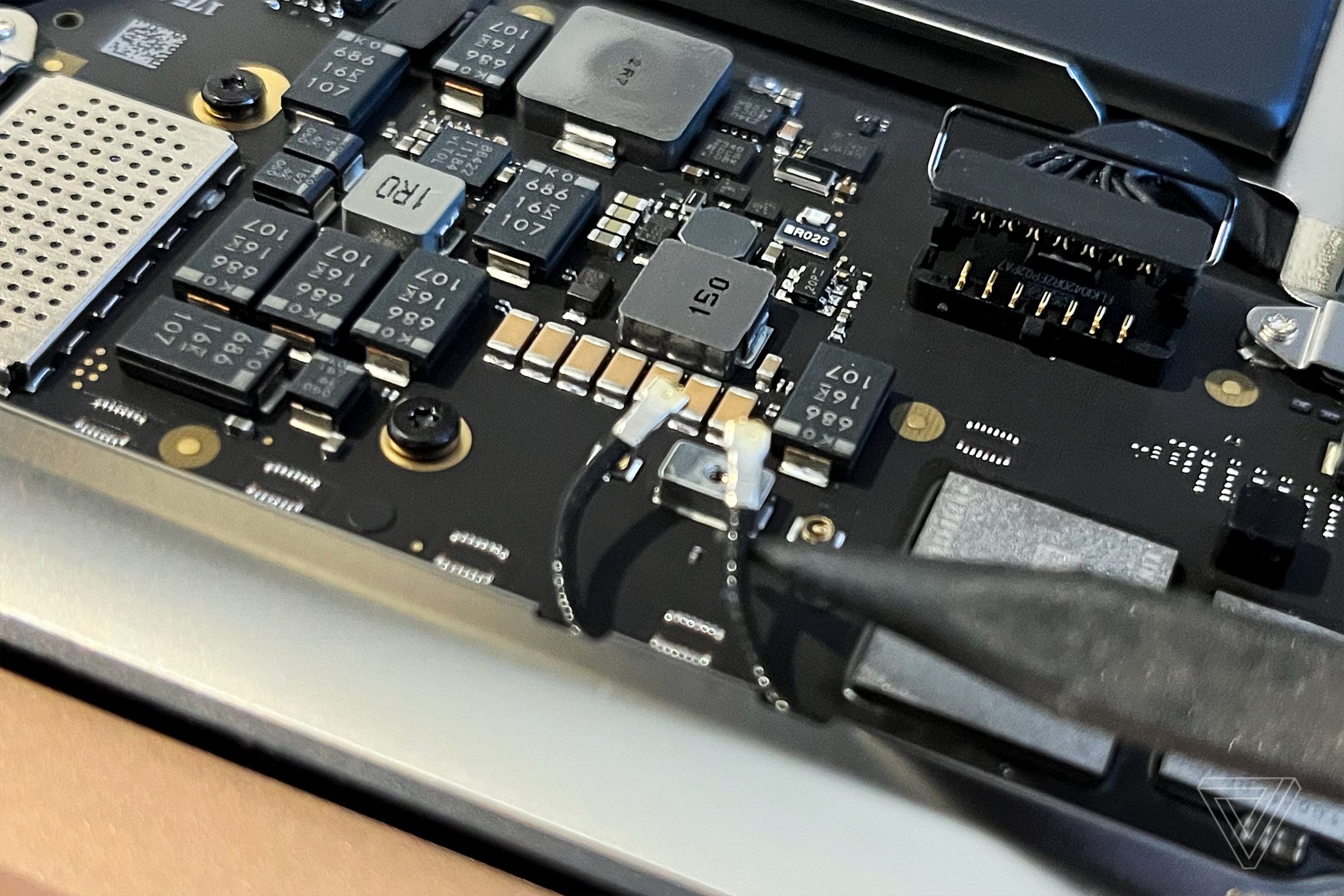 Disconnecting the antenna cables in the M1 MacBook Air. Don’t worry — these will go back when we finish up so you can keep Wi-Fi.