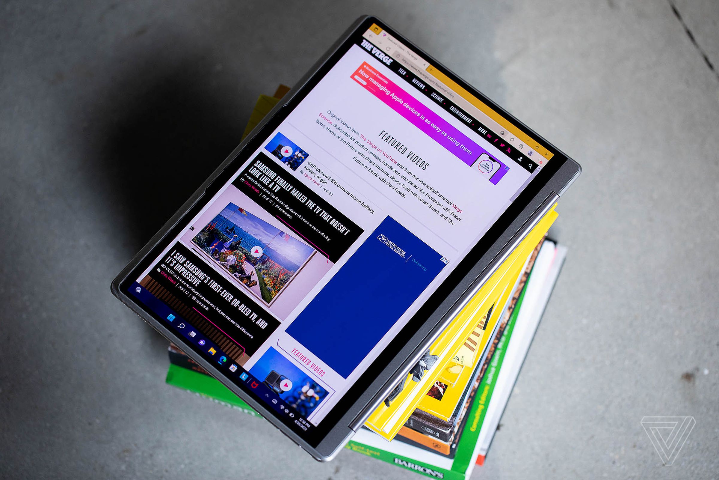 The Lenovo Yoga 9i in tablet mode on top of a stack of books.