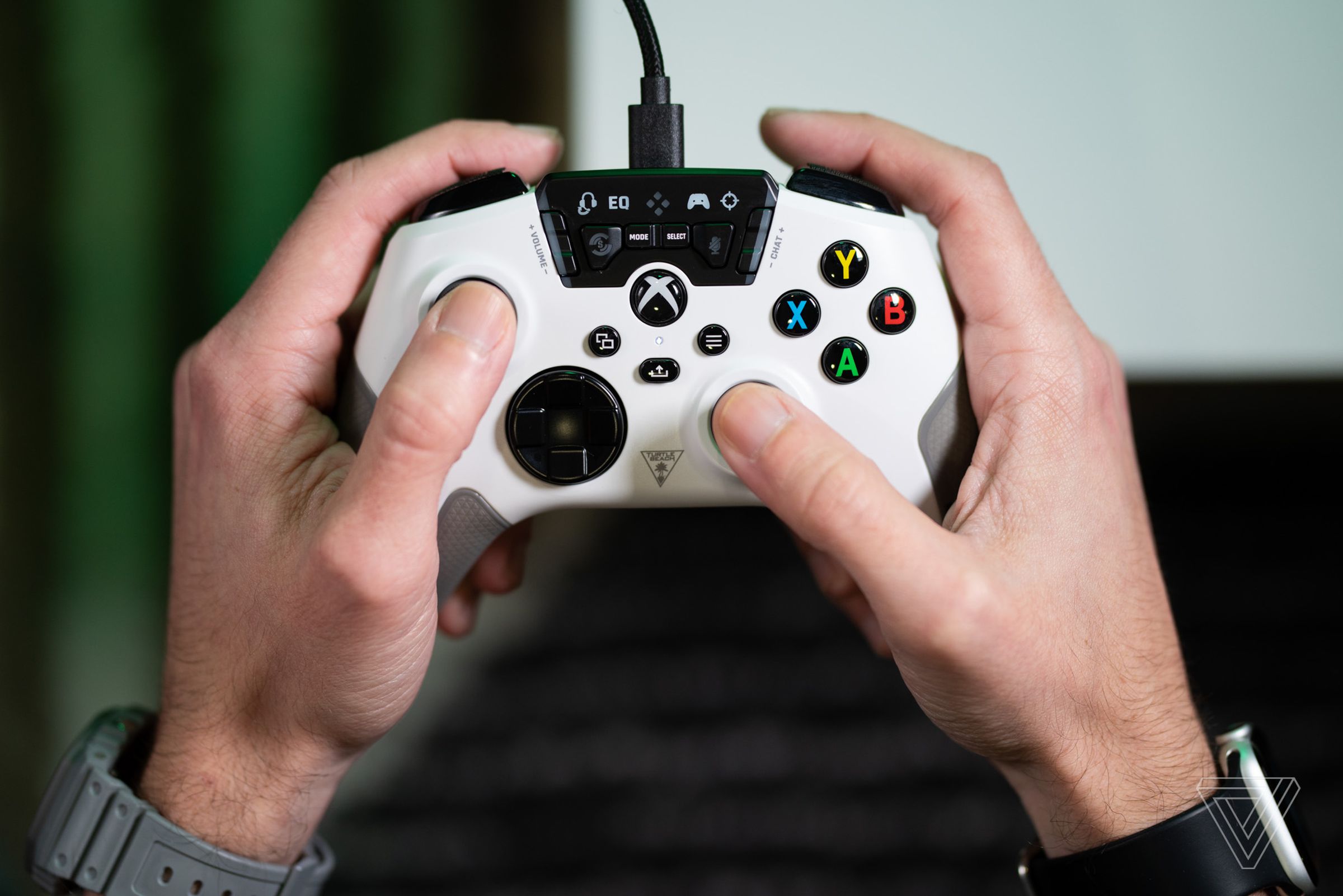A pair of hands holding and using the white Turtle Beach Recon controller for Xbox.