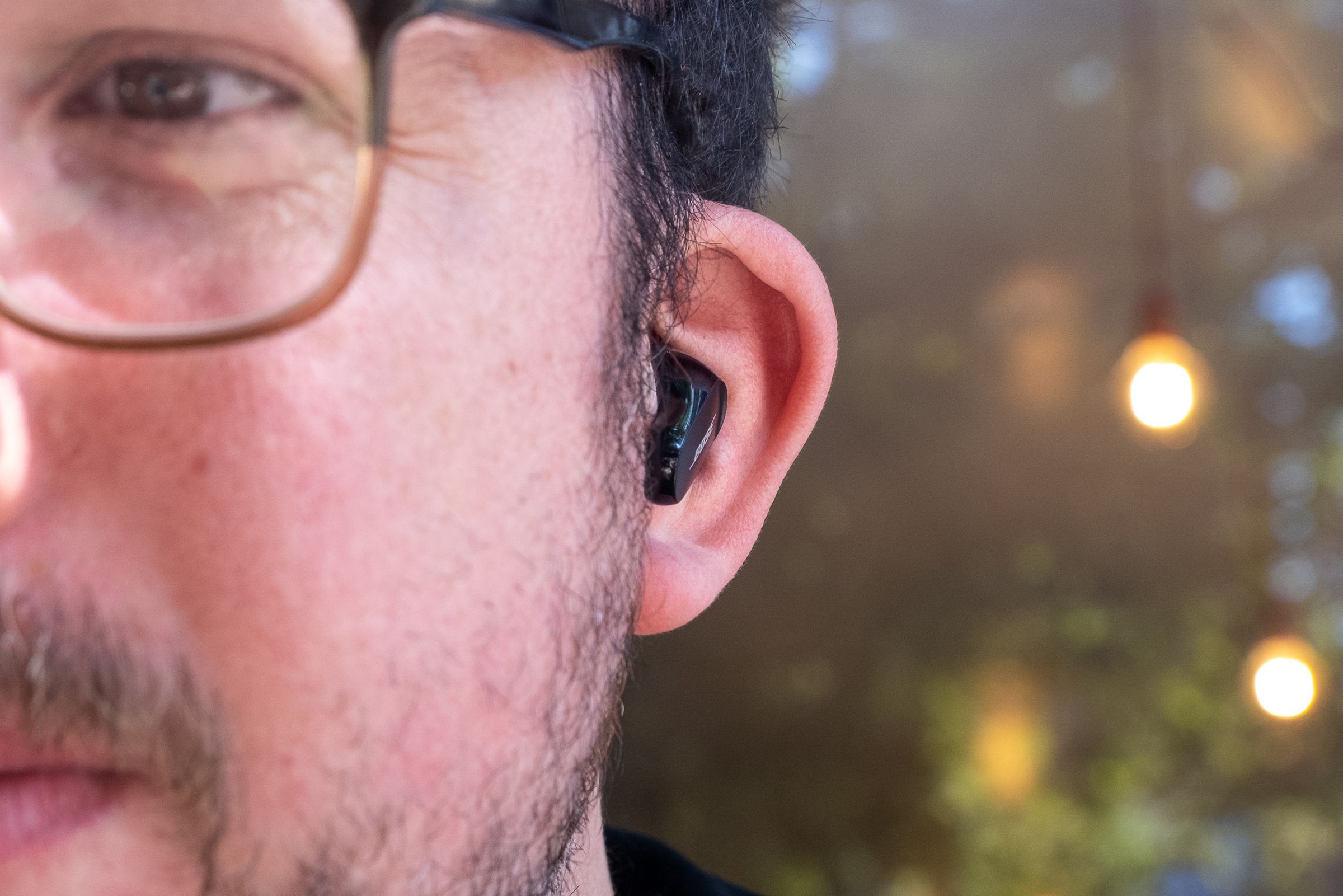 A straight-on profile shot of Bose’s QC Earbuds II in a person’s ear.
