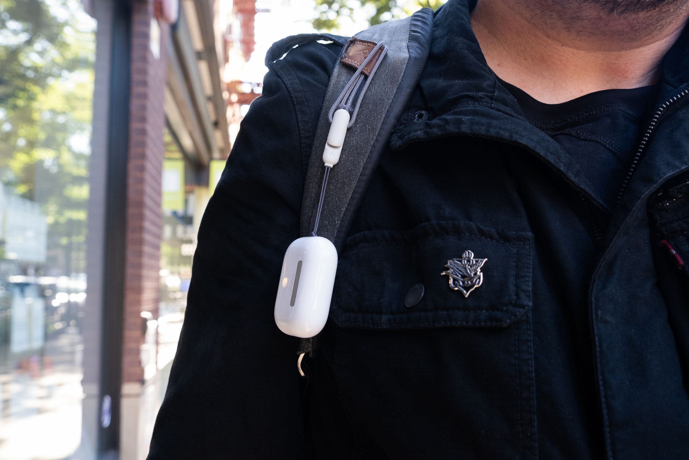 A photo of Apple’s second-generation AirPods Pro attached to a backpack with the new lanyard loop.