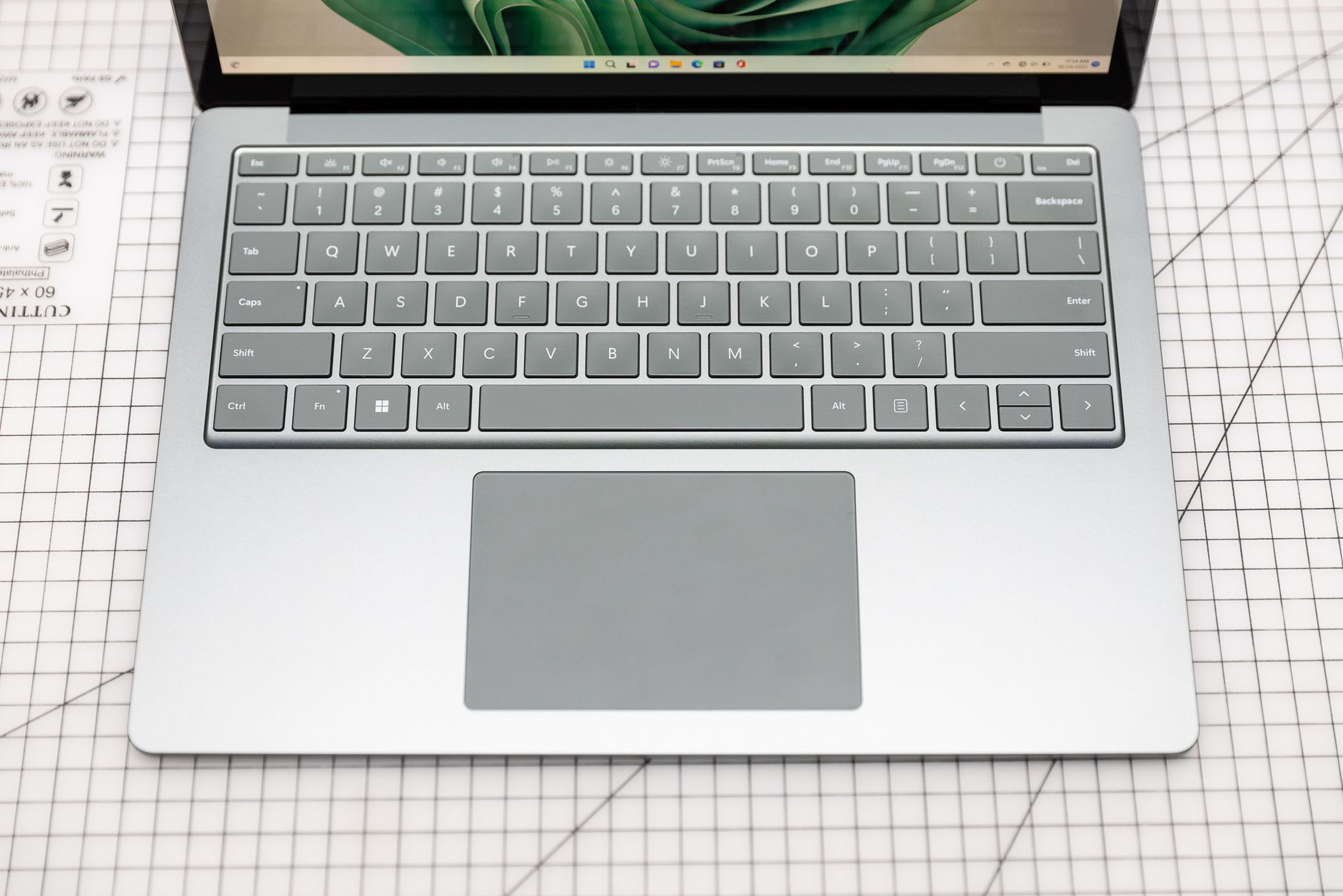 The Surface Laptop 5 keyboard on a gridded surface seen from above.