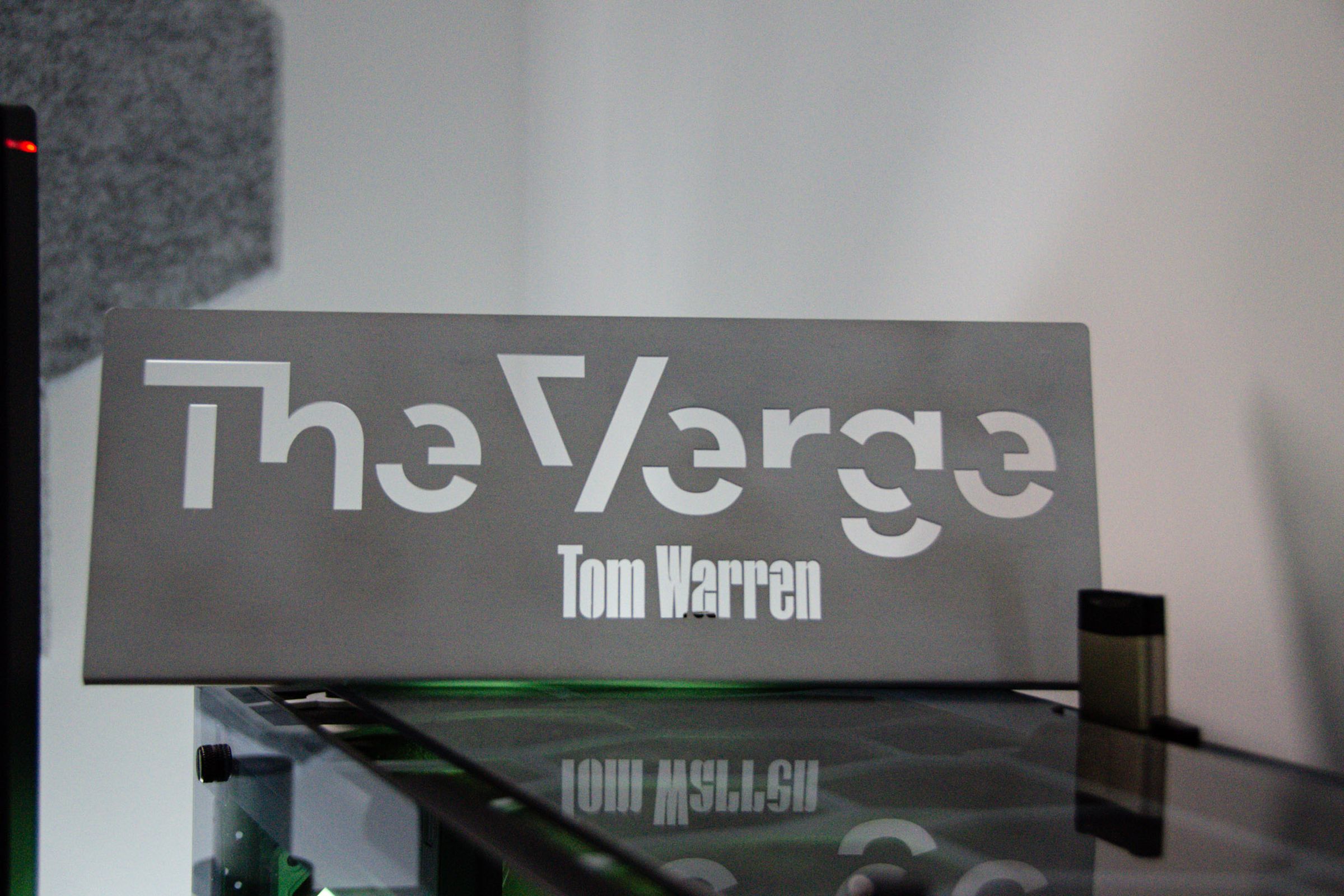 The sign says 'The Verge' and below it says 'Tom Warren'.