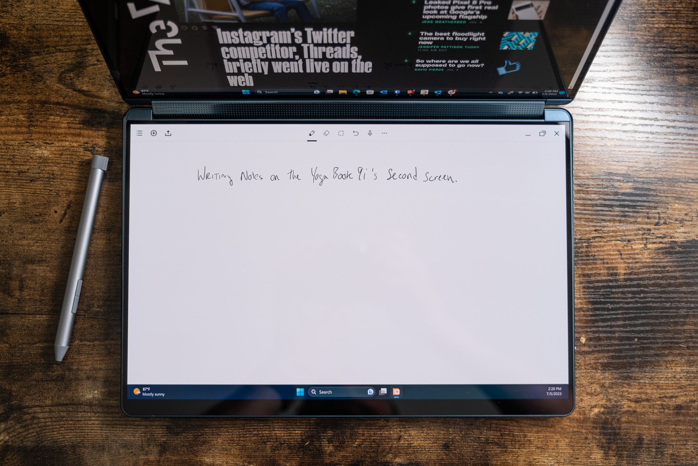 Writing notes on the Yoga Book 9i’s bottom screen with the included stylus.