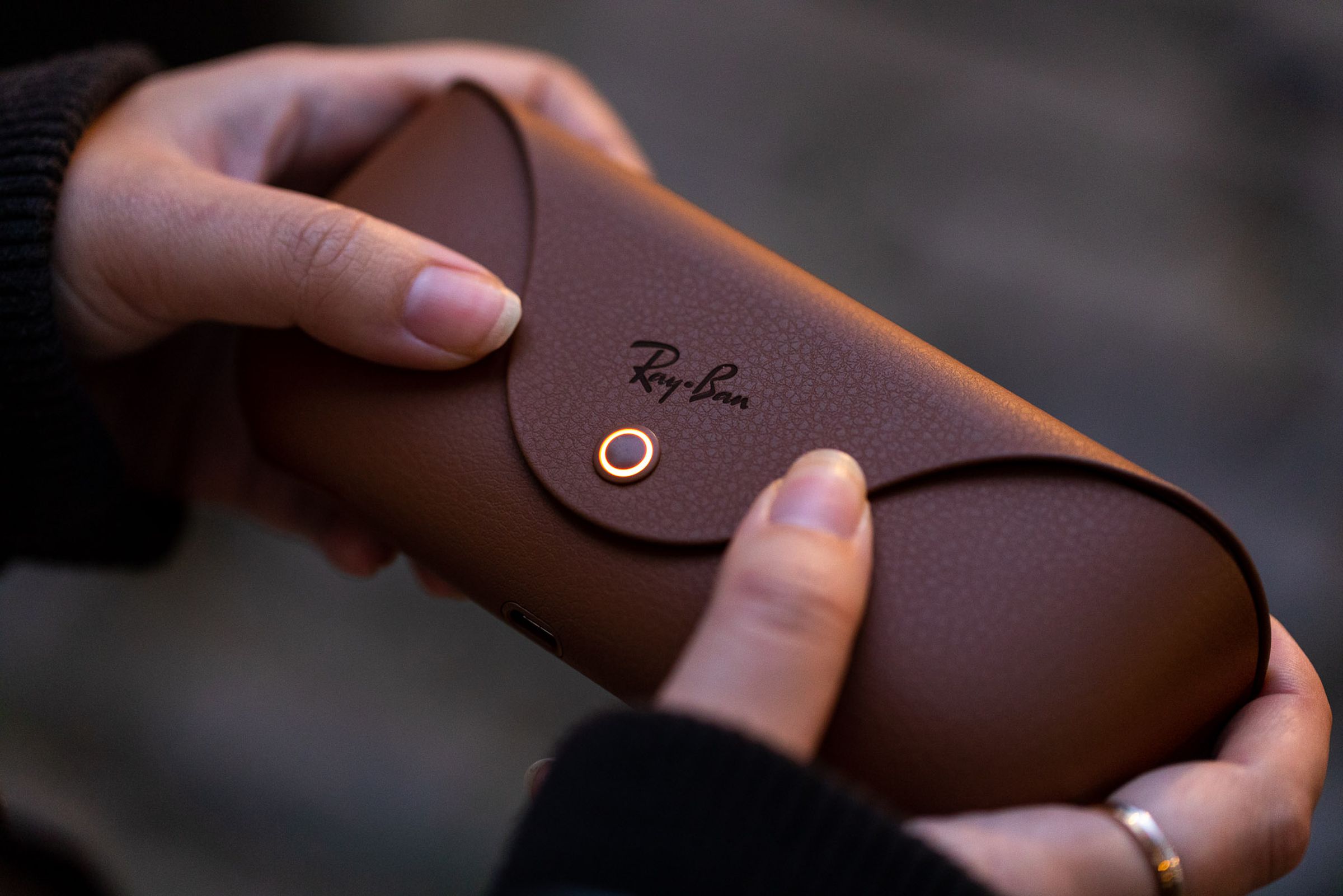 Person holding closed Ray-Ban Meta Smart Glasses charging case.