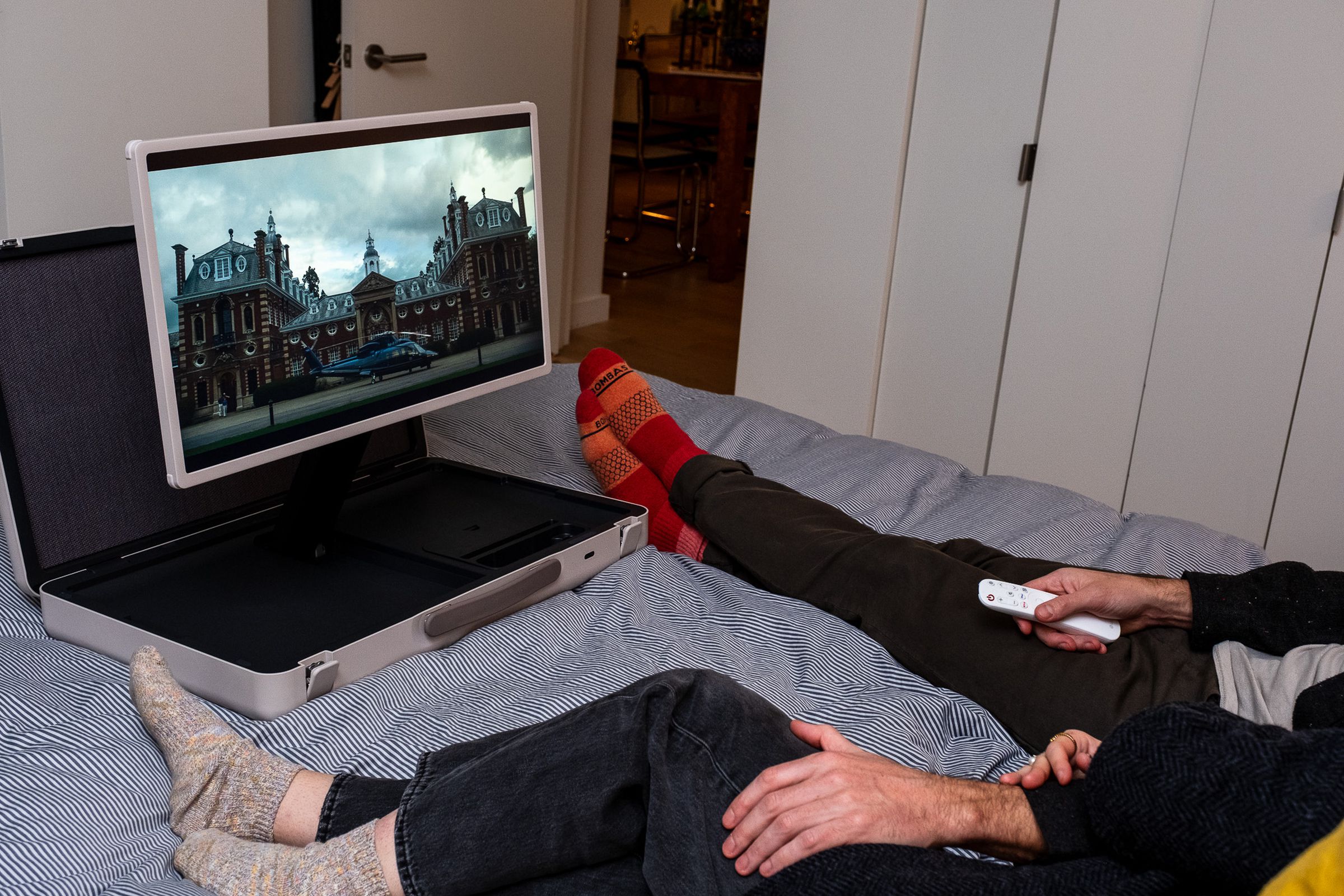 A photo of LG’s StanbyME Go briefcase TV being viewed in bed by a couple slightly out of frame to the right.