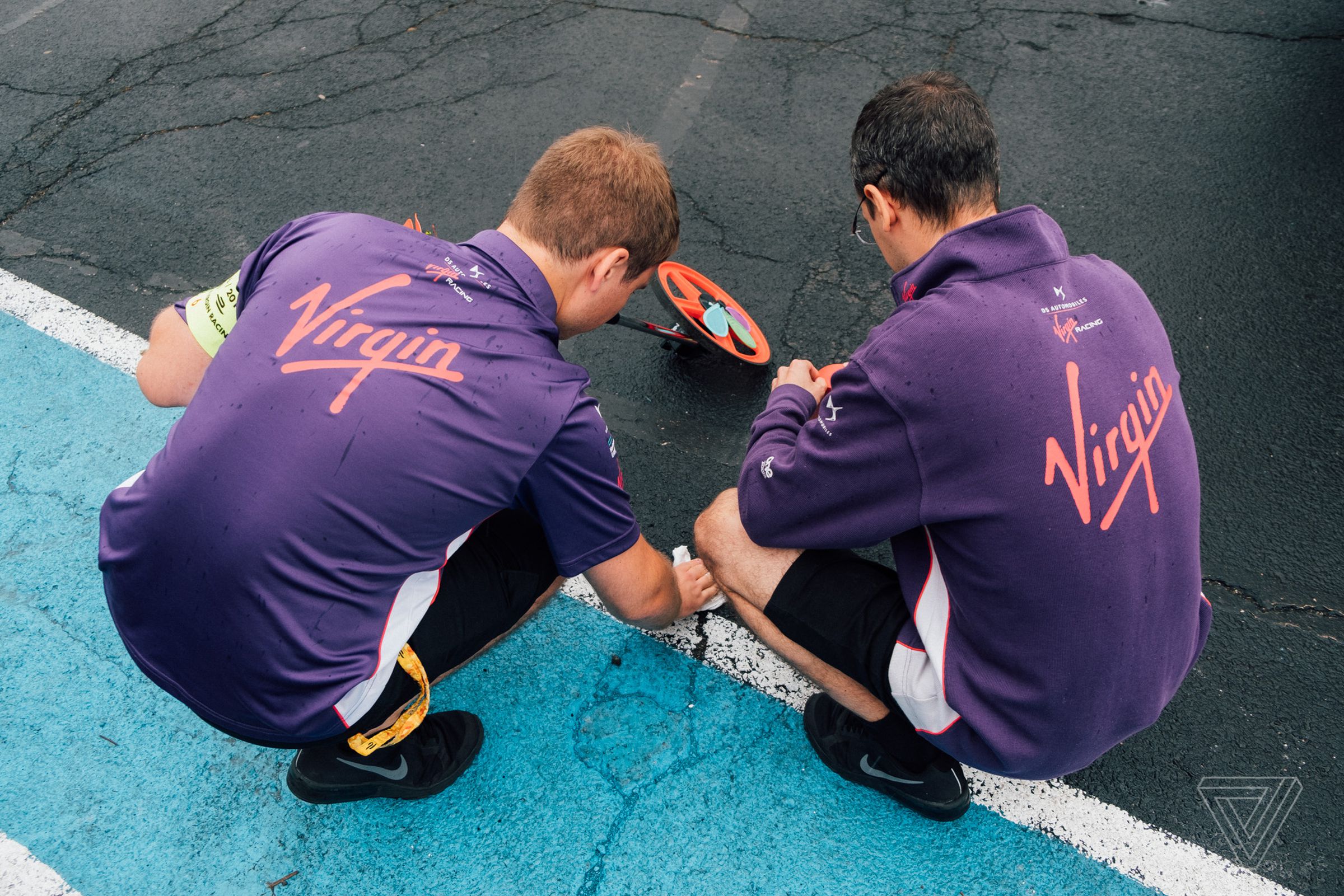 Members of the DS Virgin team lay tape that they use as a reference for timing out the drivers’ pit stops. 