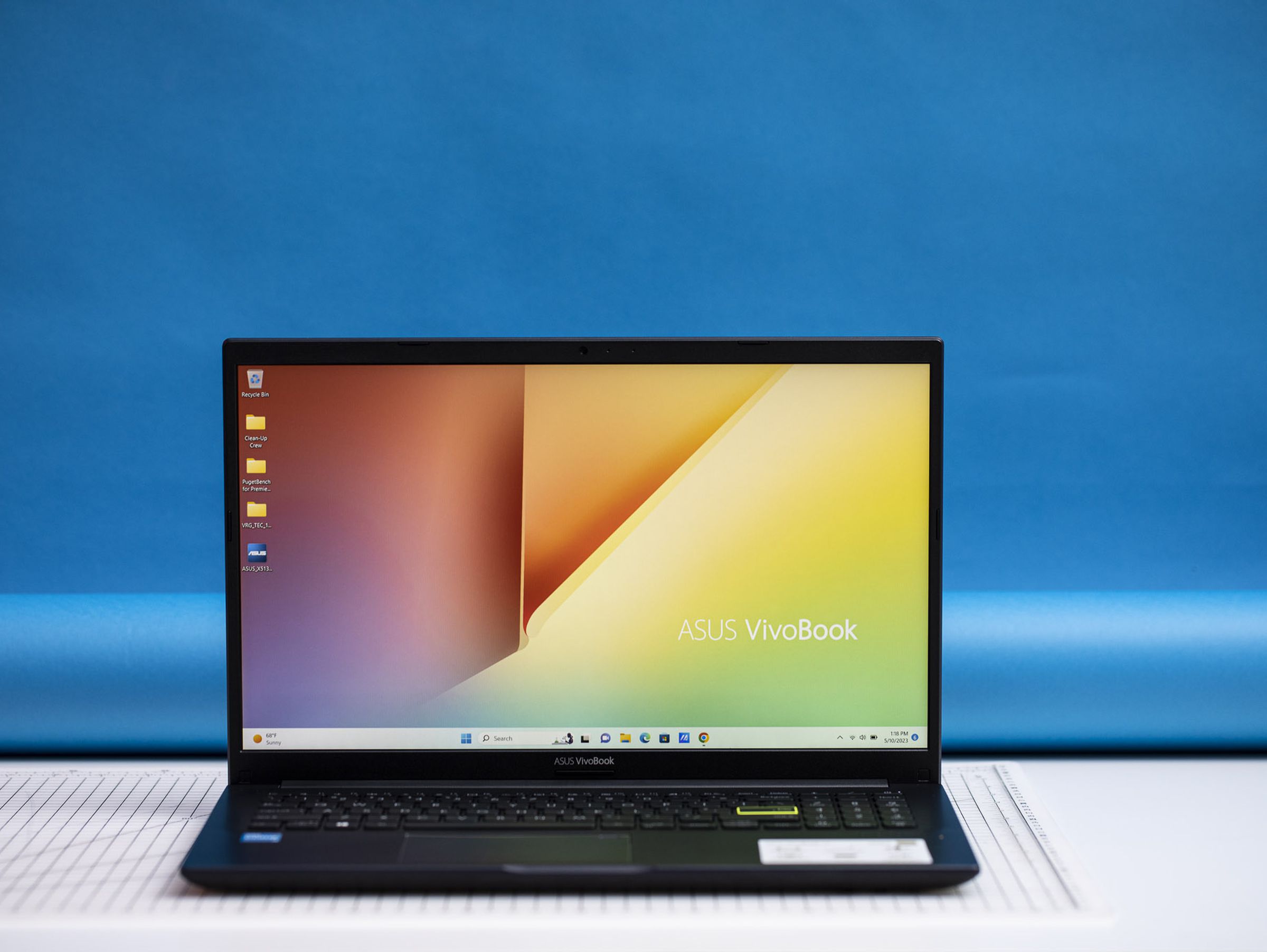 The Asus Vivobook 15 open, displaying a pastel desktop background.