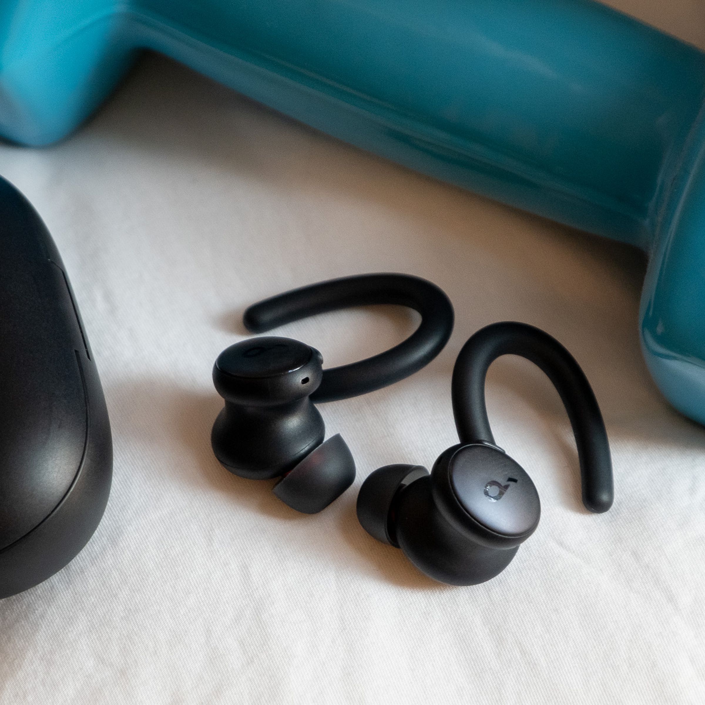 An image of Soundcoreâs Sport X10 earbuds next to a weight.